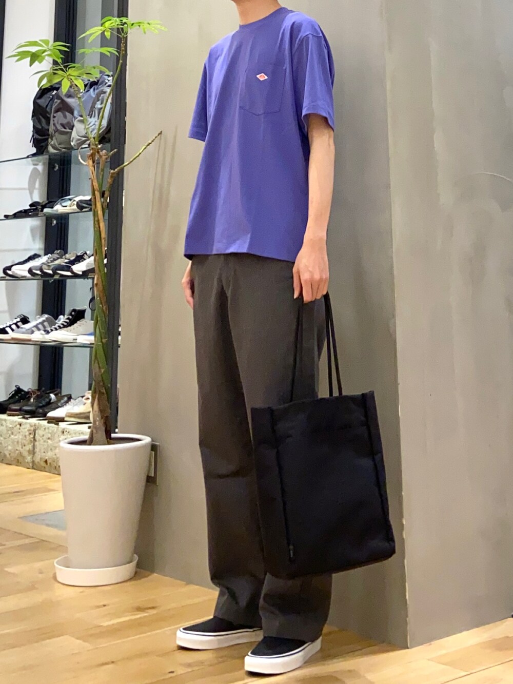 ブラック系のトートバッグ、ブラック系のスニーカー、パープル系のTシャツ/カットソーを着用したメンズの春コーディネートの2枚目の写真