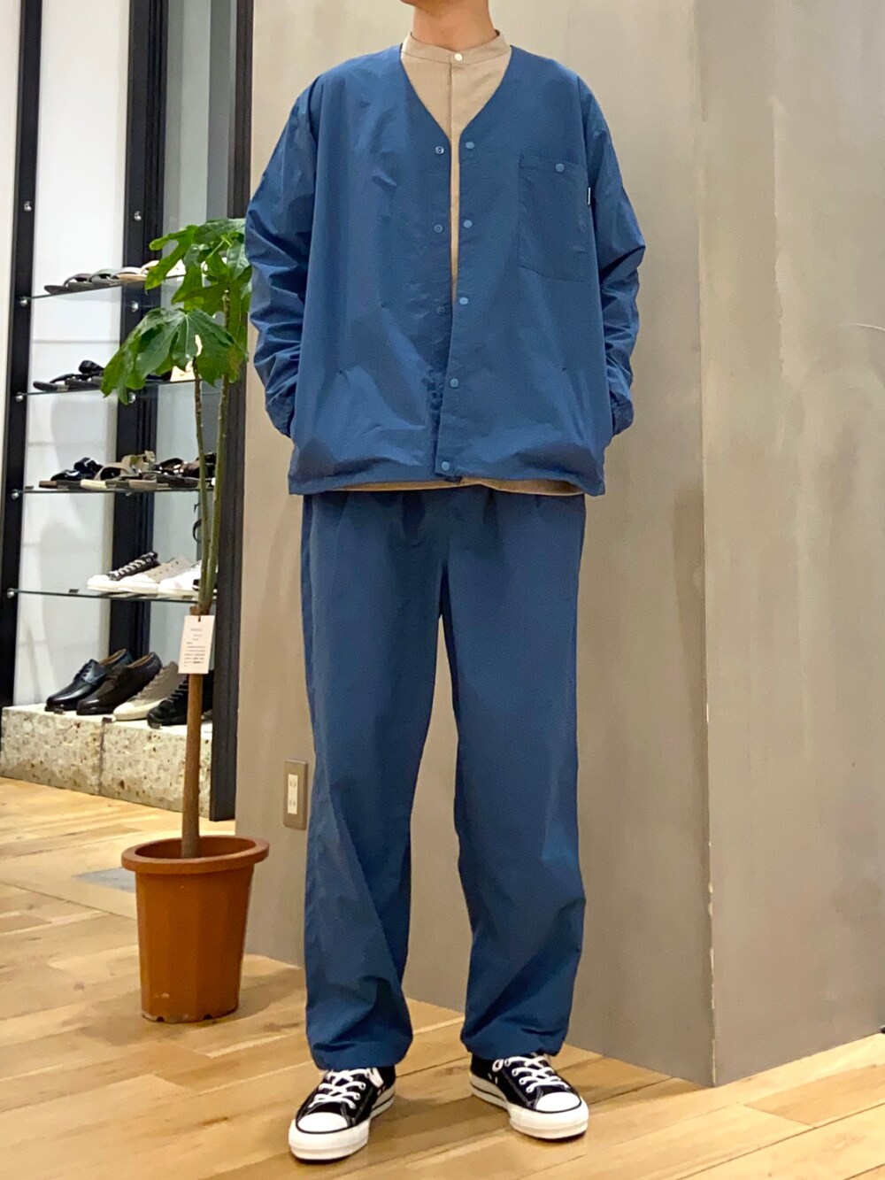 ベージュ系のシャツ/ブラウス、ブルー系のナイロンジャケット、ブルー系のその他パンツを着用したメンズの春コーディネートの4枚目の写真