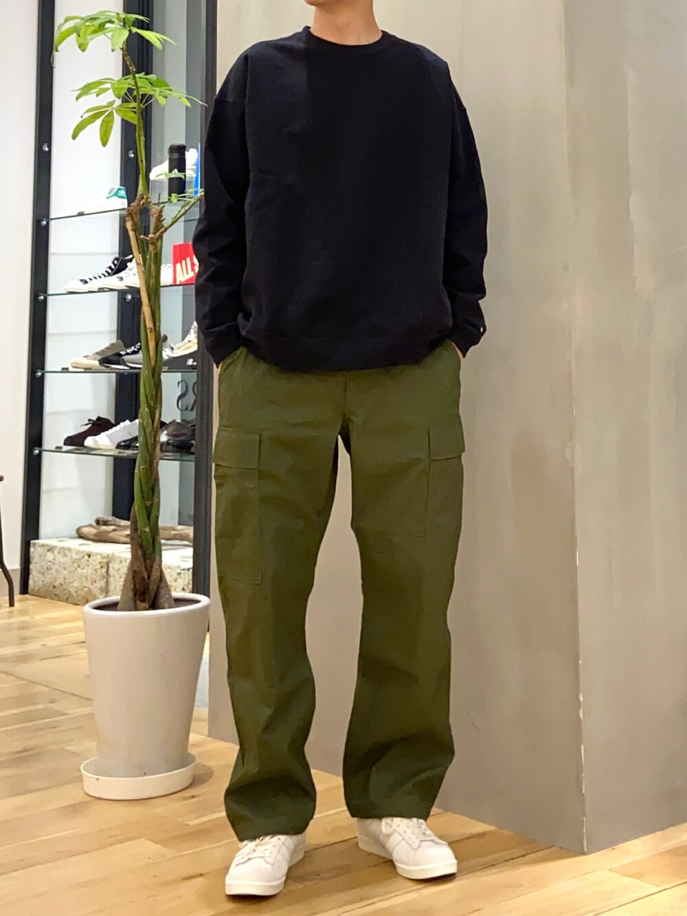 グレー系のステンカラーコート、グリーン系のその他パンツ、ベージュ系のスニーカーを着用したメンズの春コーディネートの3枚目の写真