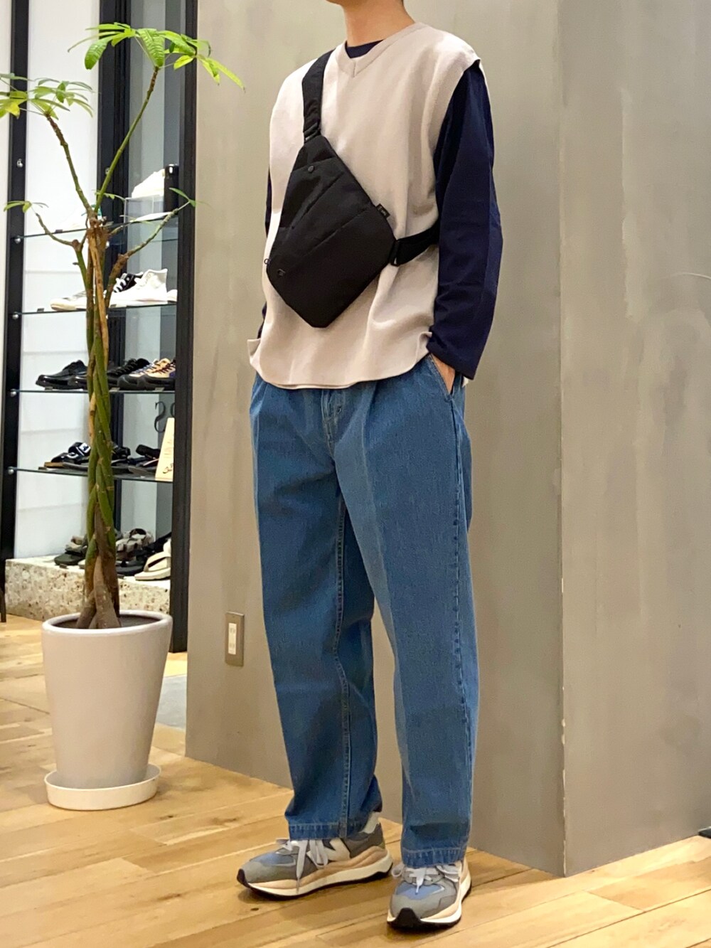 グレー系のベスト、ブルー系のTシャツ/カットソー、ブラック系のショルダーバッグを着用したメンズの春コーディネートの4枚目の写真