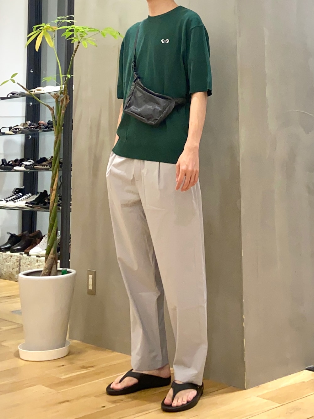 グリーン系のTシャツ/カットソー、グレー系のショルダーバッグ、ブラック系のサンダルを着用したメンズの春コーディネートの2枚目の写真