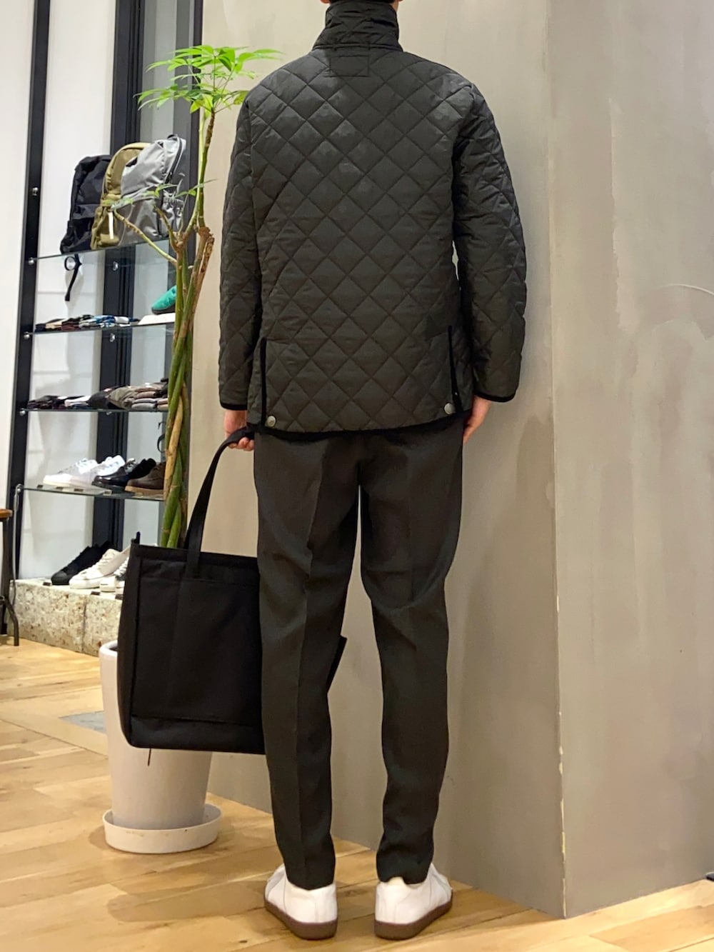 ブラック系のその他アウター、ホワイト系のニット/セーター、ホワイト系のスニーカーを着用したメンズの冬コーディネートの3枚目の写真