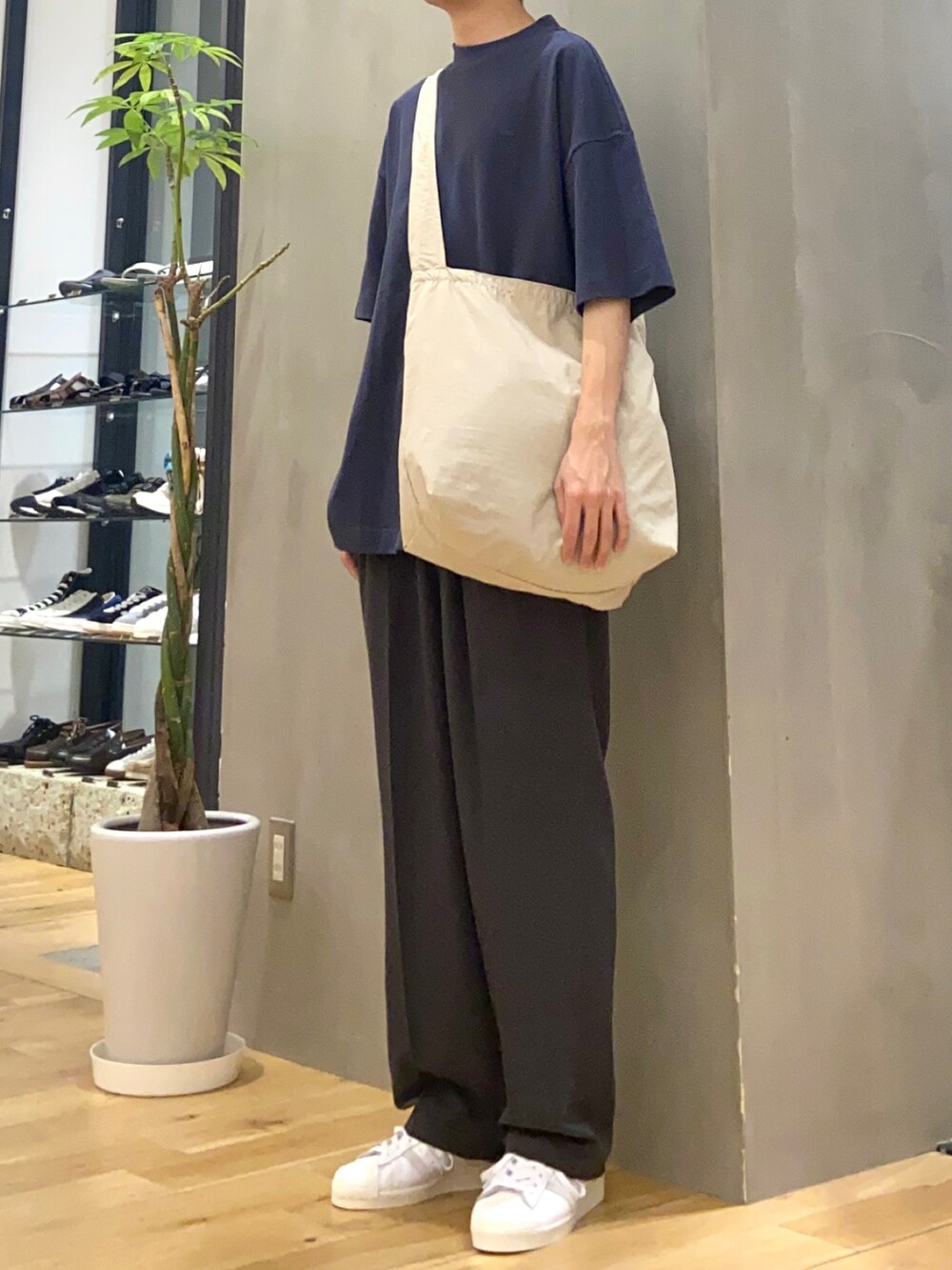 ブルー系のTシャツ/カットソー、グレー系のショルダーバッグ、グレー系のスラックスを着用したメンズの春コーディネートの2枚目の写真