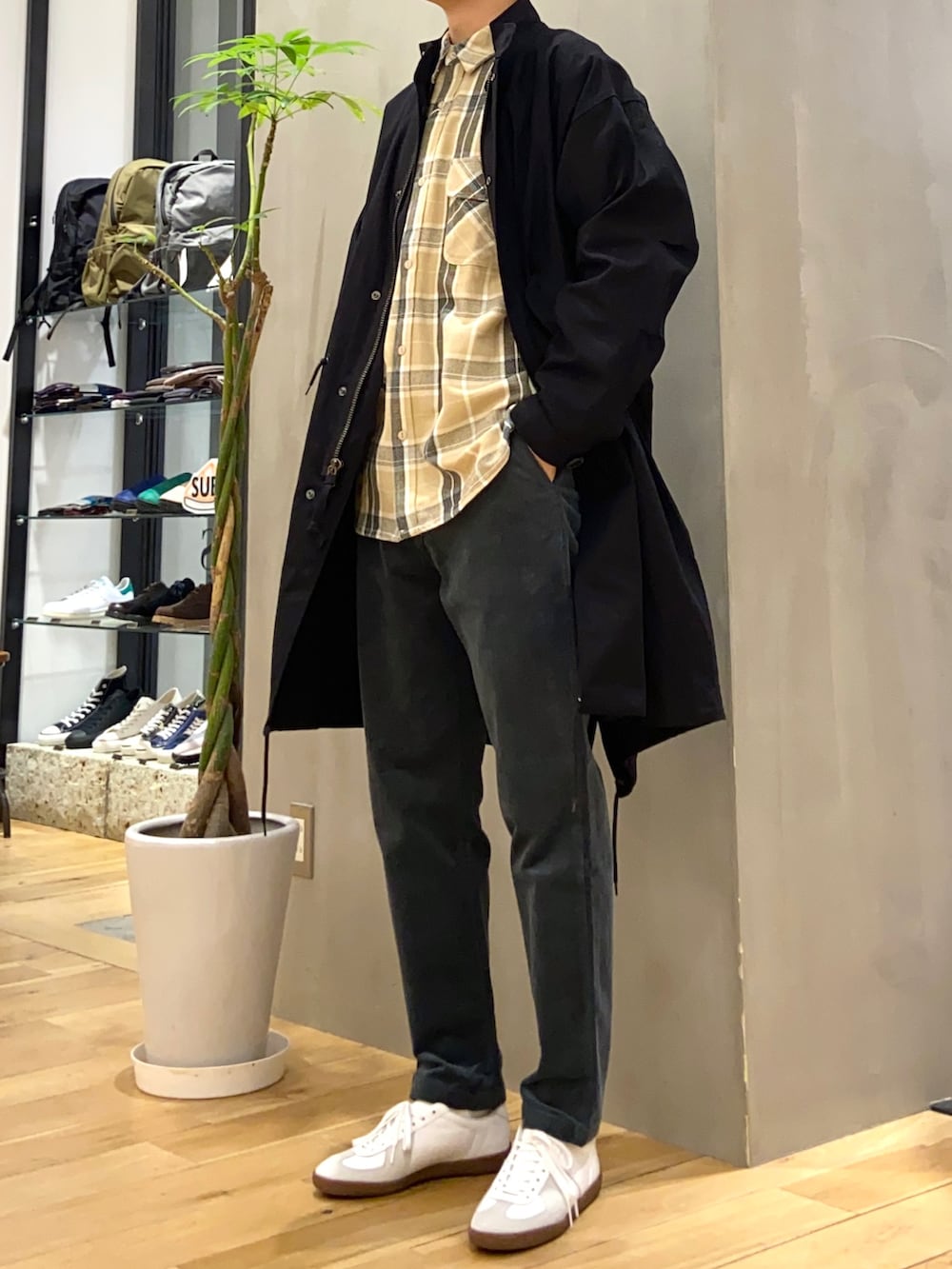 ブラック系のモッズコート、ベージュ系のシャツ/ブラウス、ホワイト系のスニーカーを着用したメンズの冬コーディネートの2枚目の写真