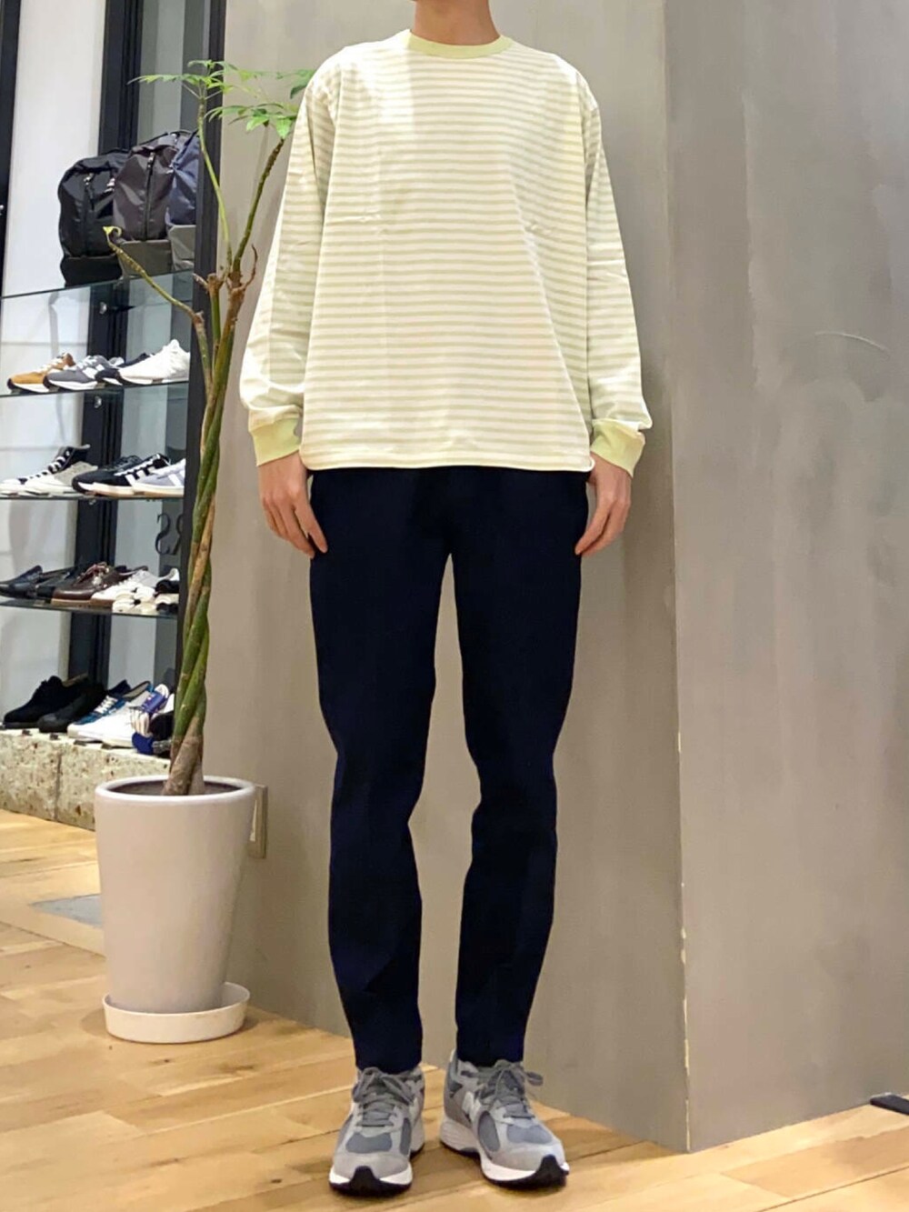 ホワイト系のブルゾン、イエロー系のTシャツ/カットソー、ブルー系のデニムパンツを着用したメンズの春コーディネートの2枚目の写真