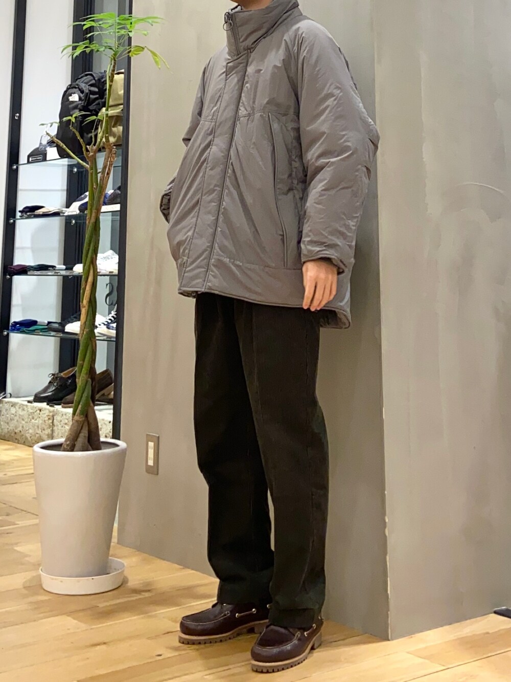 グレー系のブルゾン、ブラウン系のニット/セーター、ブラウン系のスニーカーを着用したメンズの冬コーディネートの3枚目の写真
