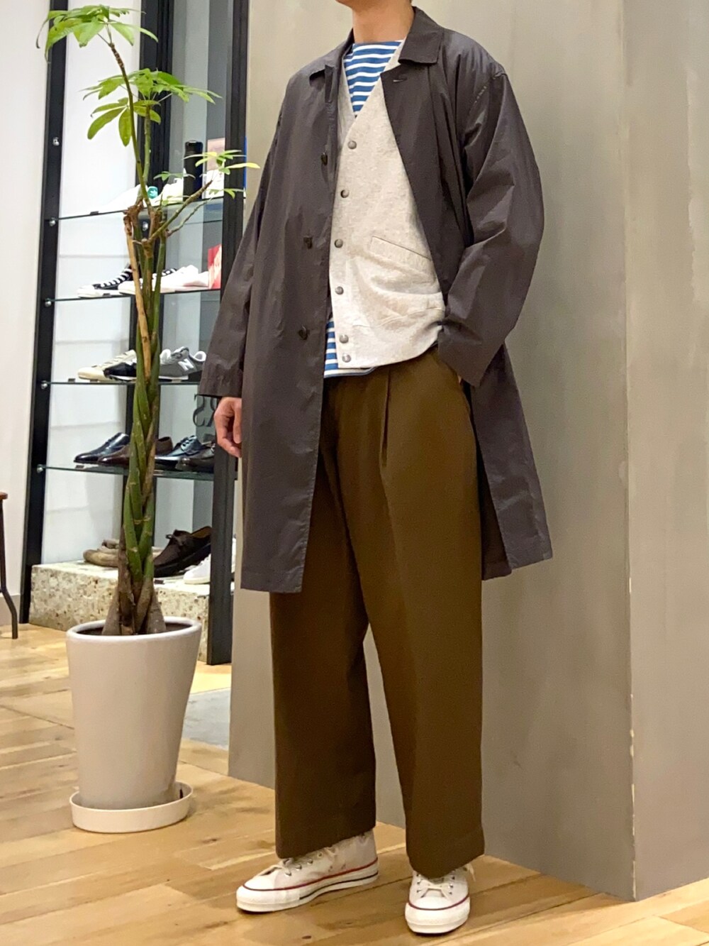 グレー系のステンカラーコート、グレー系のカーディガン/ボレロ、ブラウン系のその他パンツを着用したメンズの冬コーディネートの3枚目の写真