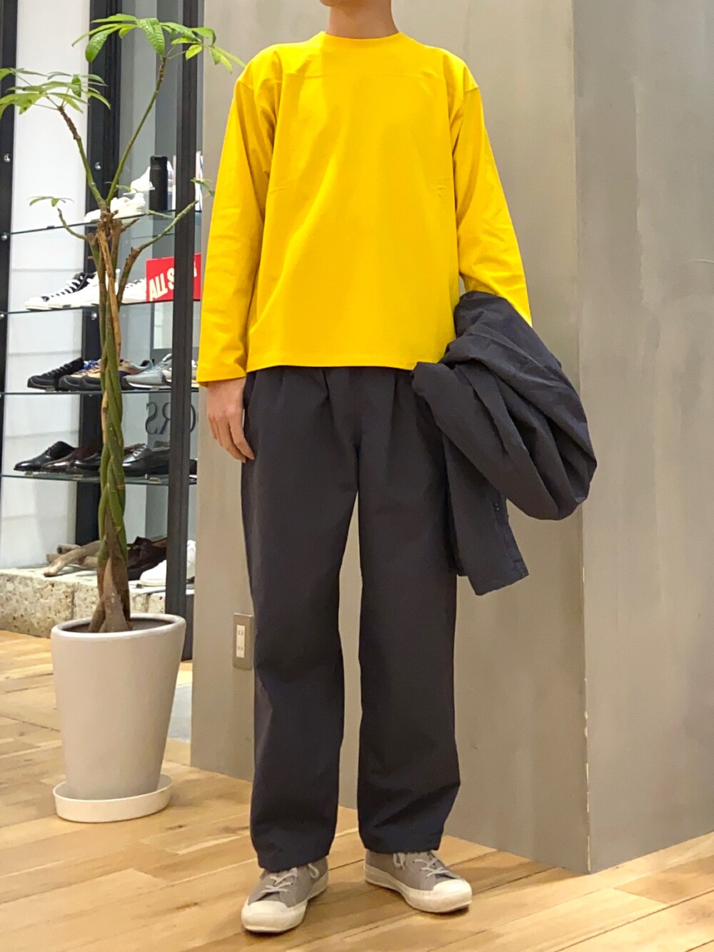 グレー系のナイロンジャケット、グレー系のその他パンツ、イエロー系のTシャツ/カットソーを着用したメンズの春コーディネートの2枚目の写真