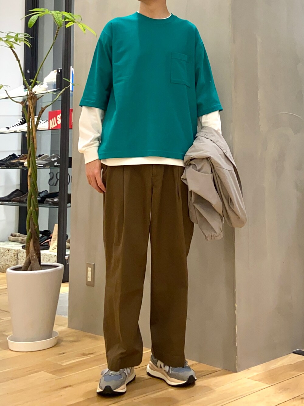 グレー系のナイロンジャケット、グリーン系のTシャツ/カットソー、ホワイト系のTシャツ/カットソーを着用したメンズの春コーディネートの2枚目の写真