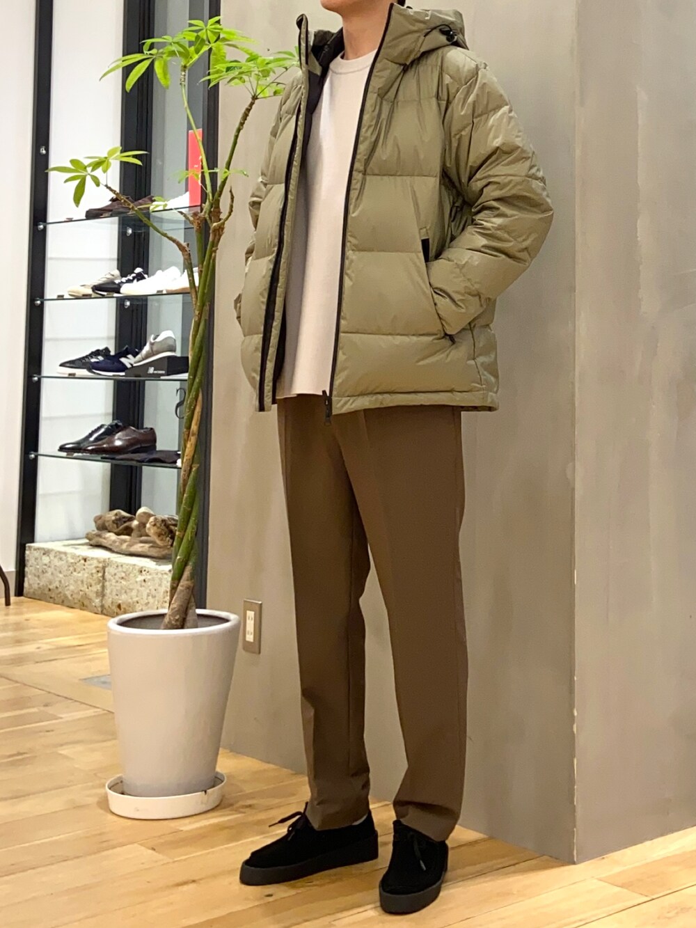 グリーン系のダウンジャケット/コート、ホワイト系のニット/セーター、ブラック系のその他シューズを着用したメンズの冬コーディネートの4枚目の写真