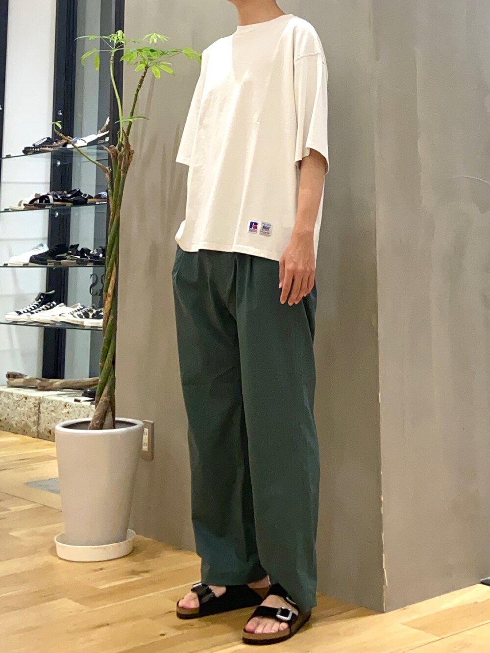 ホワイト系のTシャツ/カットソー、グリーン系のその他パンツ、ブラック系のサンダルを着用したメンズの夏コーディネートの2枚目の写真