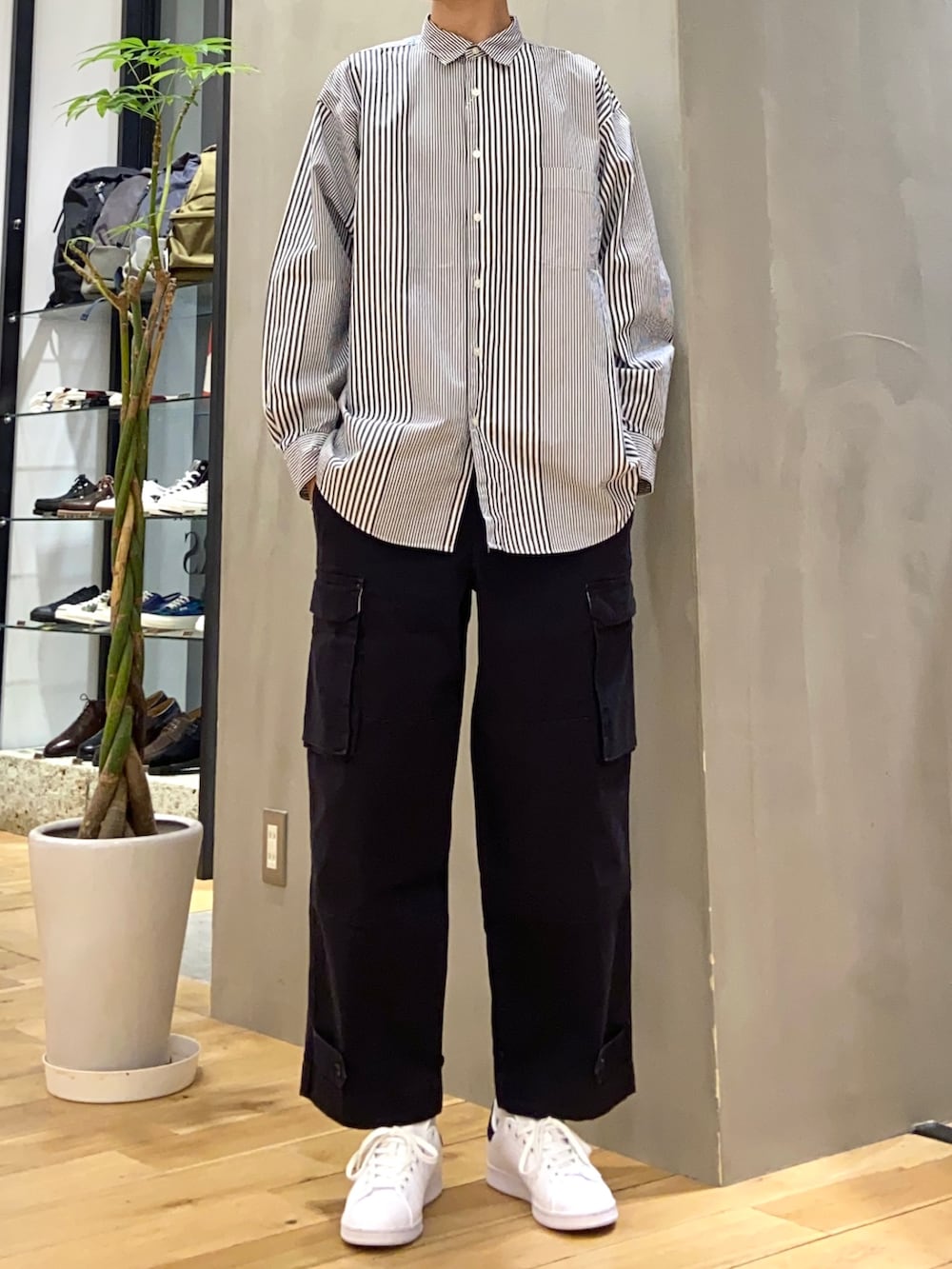 グリーン系のダウンジャケット/コート、ブルー系のシャツ/ブラウス、ブラック系のスニーカーを着用したメンズの冬コーディネートの2枚目の写真