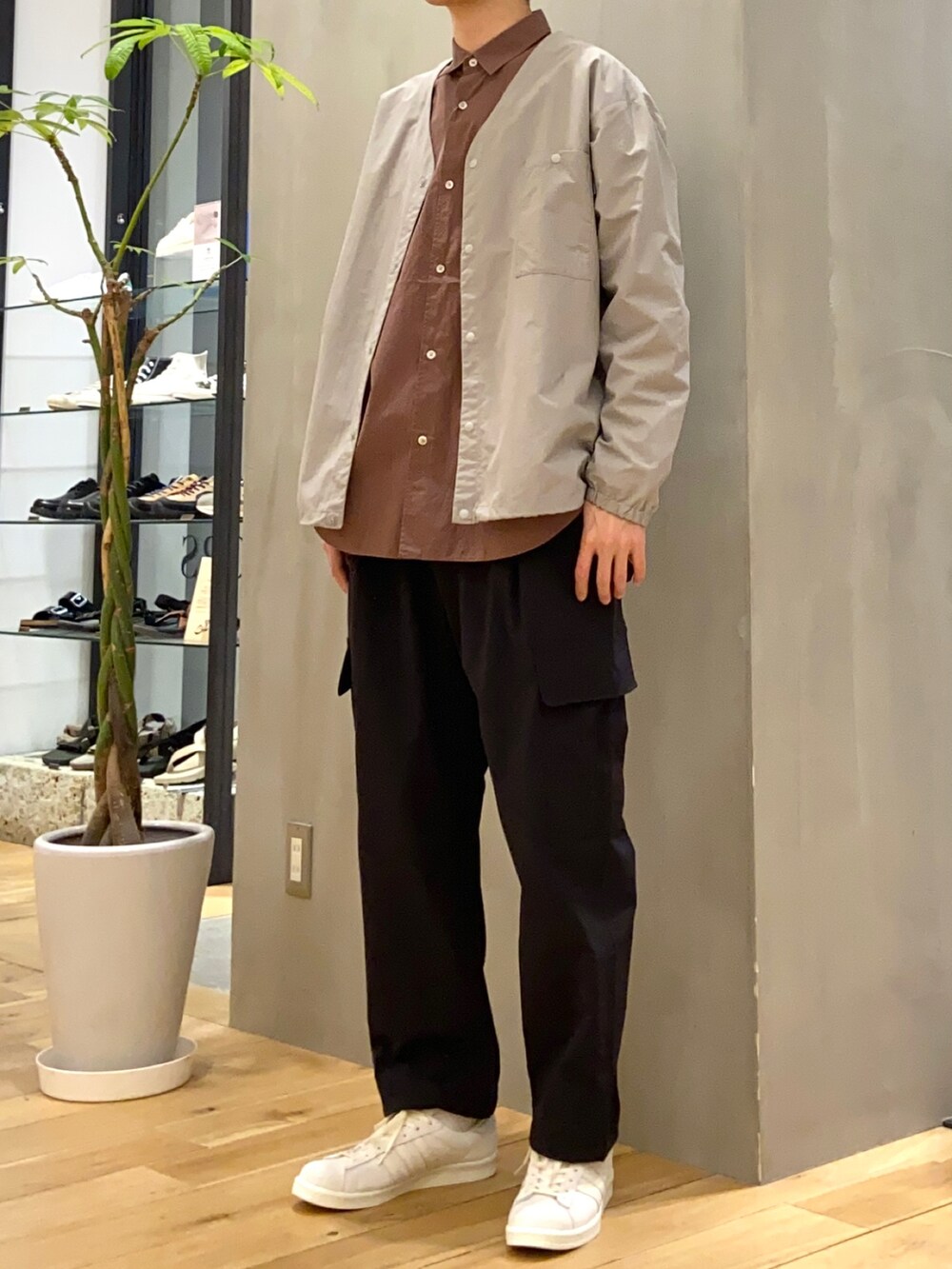 グレー系のナイロンジャケット、ブラウン系のシャツ/ブラウス、ベージュ系のスニーカーを着用したメンズの春コーディネートの3枚目の写真