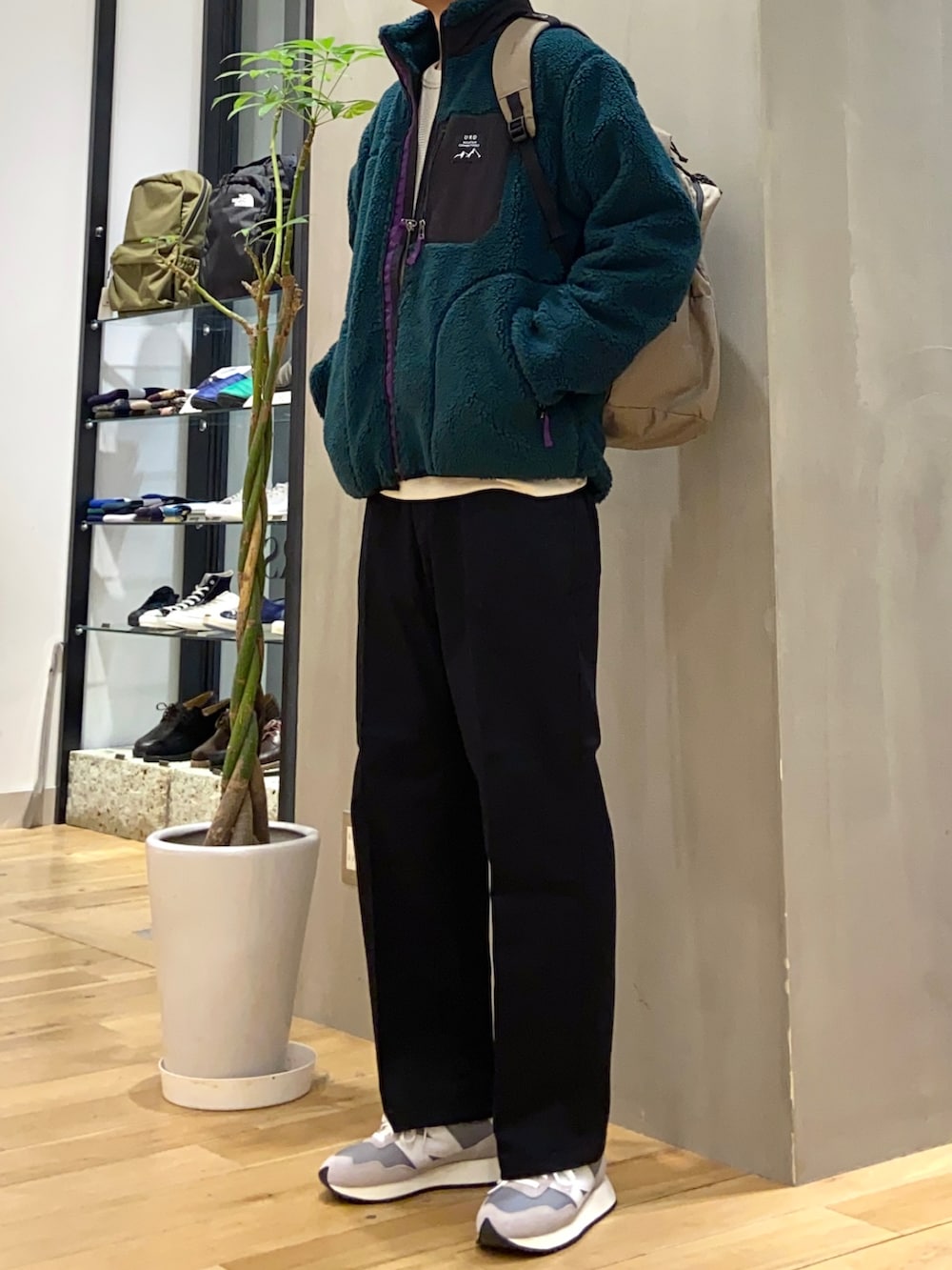 グリーン系のブルゾン、ブラック系のその他パンツ、ベージュ系のTシャツ/カットソーを着用したメンズの冬コーディネートの2枚目の写真
