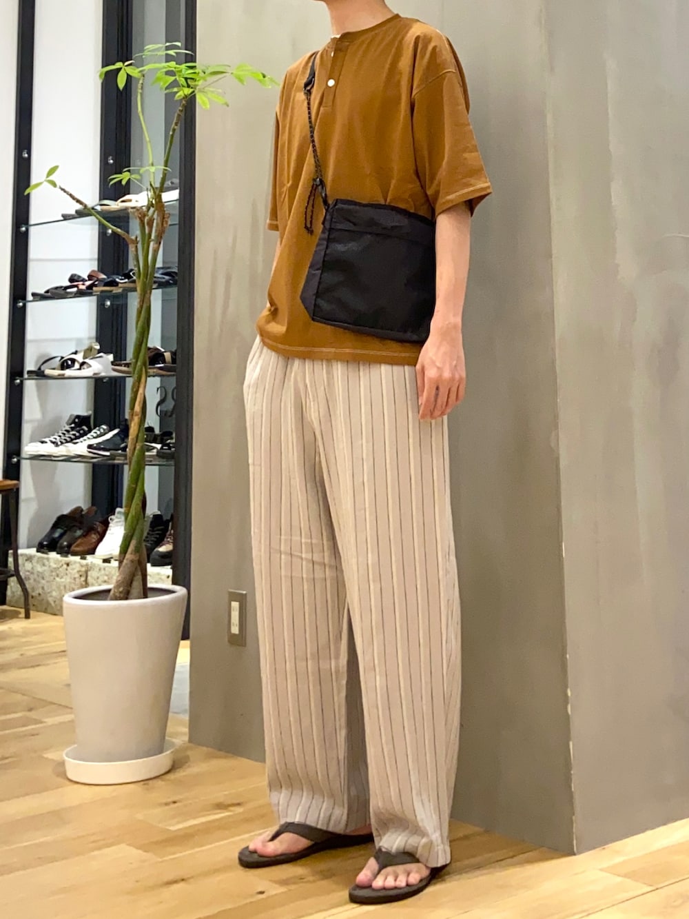 ブラウン系のTシャツ/カットソー、ベージュ系のその他パンツ、グレー系のサンダルを着用したメンズの夏コーディネートの2枚目の写真