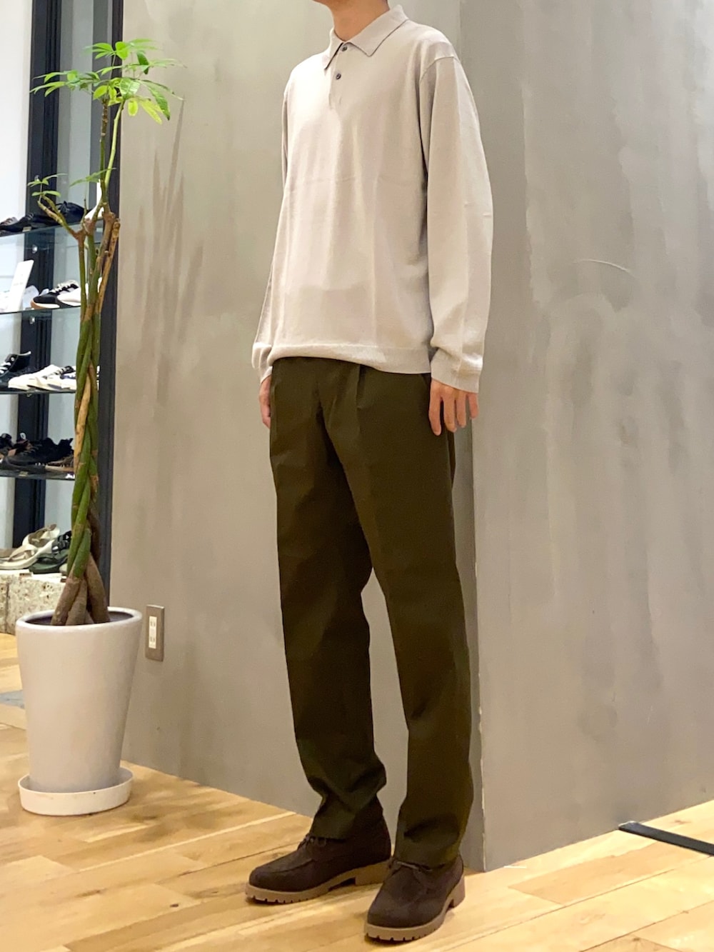 グレー系のポロシャツ、グリーン系のスーツパンツ、ブラウン系のその他シューズを着用したメンズの秋コーディネートの2枚目の写真