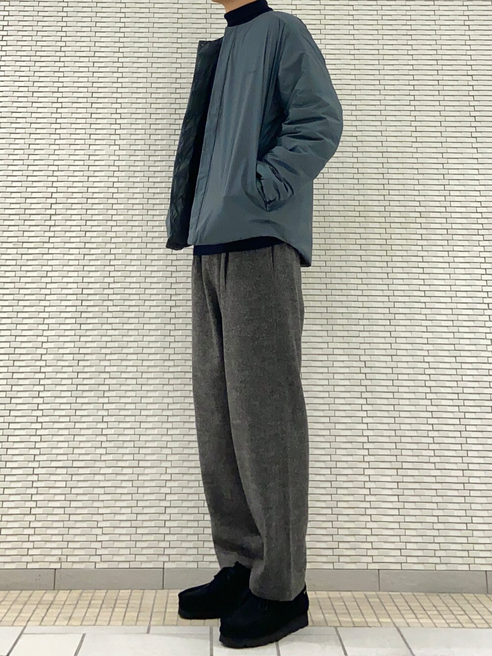 ブルー系のダウンジャケット/コート、ブルー系のニット/セーター、グレー系のその他パンツを着用したメンズの冬コーディネートの2枚目の写真