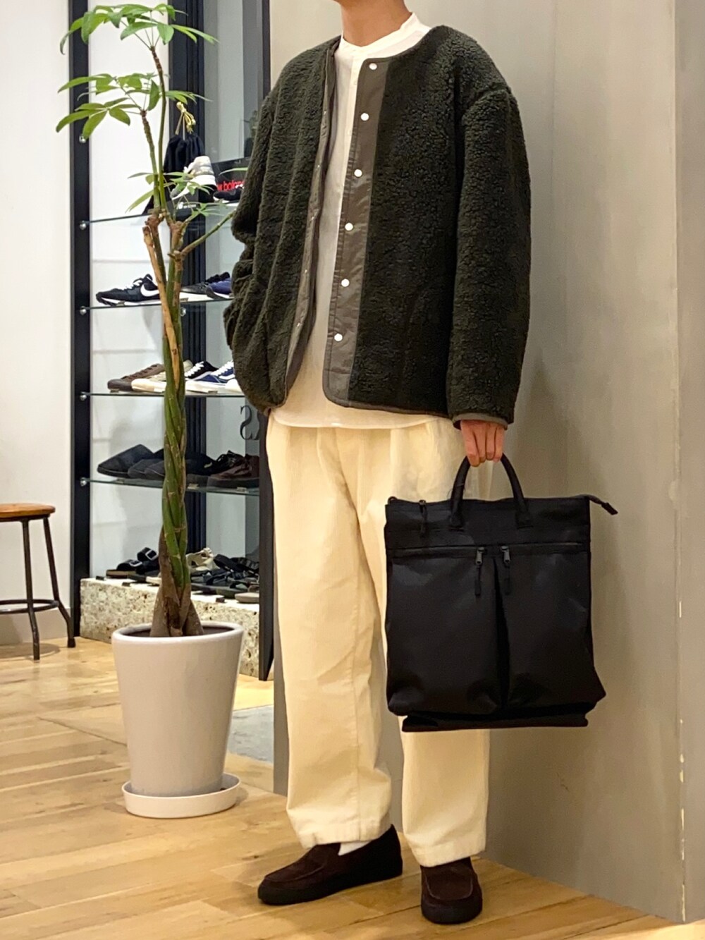 グリーン系のブルゾン、ホワイト系のシャツ/ブラウス、ブラウン系のローファーを着用したメンズの秋コーディネートの2枚目の写真