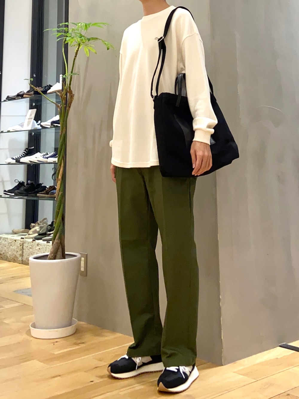 ホワイト系のTシャツ/カットソー、ブラック系のトートバッグ、ブラック系のスニーカーを着用したメンズの秋コーディネートの2枚目の写真