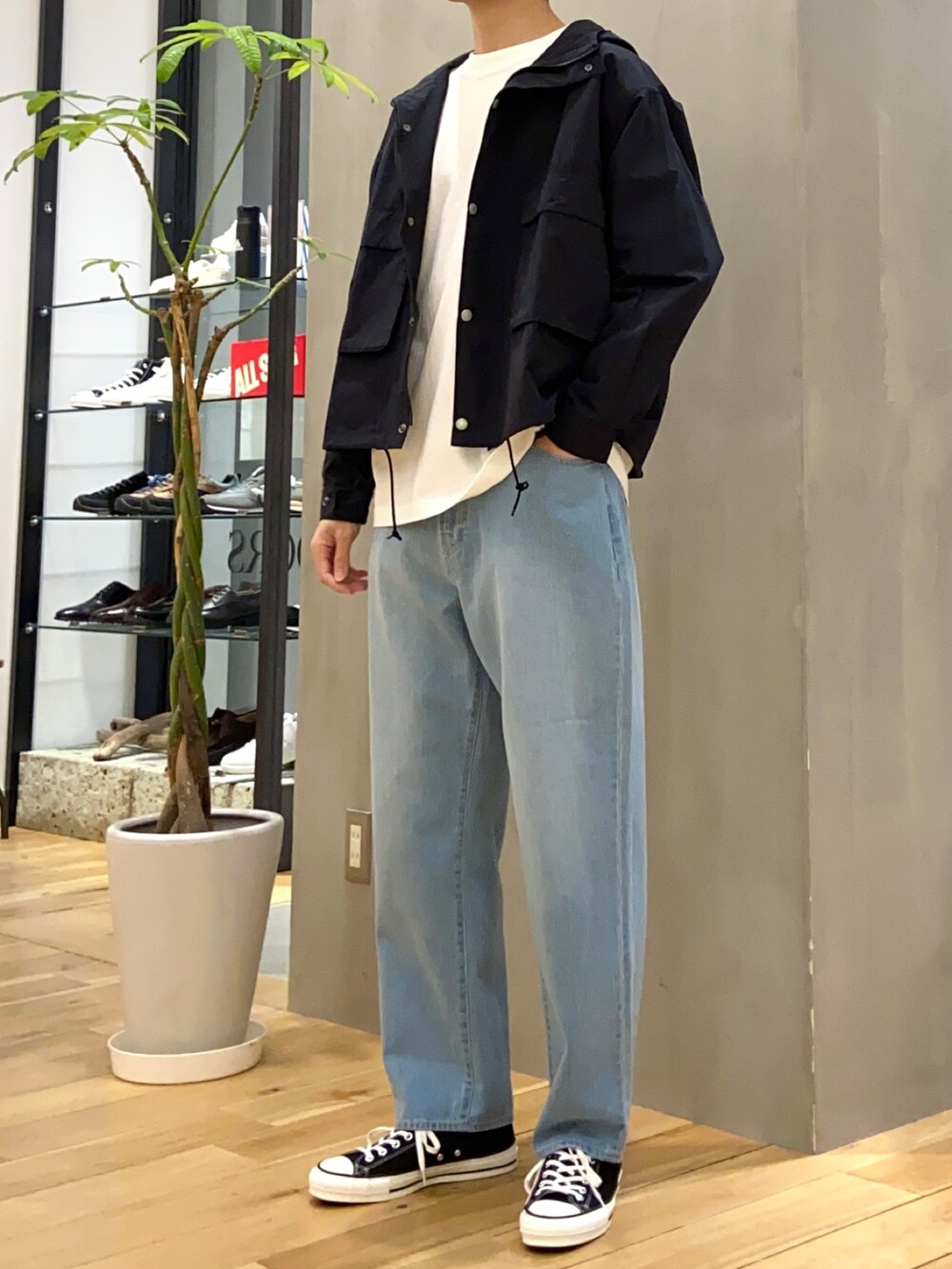 ブラック系のマウンテンパーカー、ホワイト系のTシャツ/カットソー、ブルー系のデニムパンツを着用したメンズの春コーディネートの3枚目の写真
