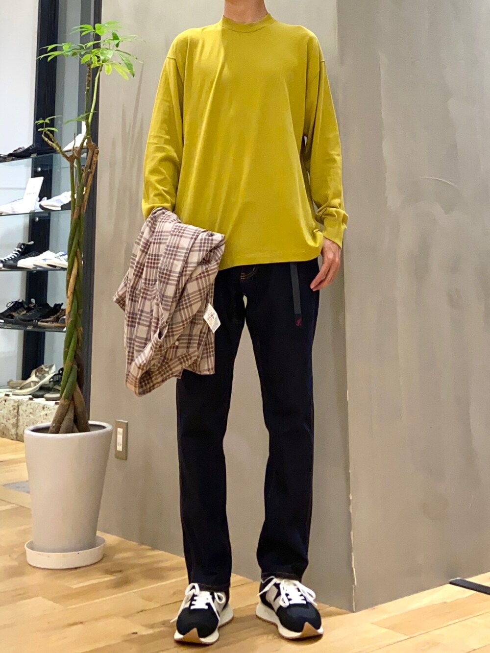 ベージュ系のシャツ/ブラウス、イエロー系のニット/セーター、ブルー系のその他パンツを着用したメンズの秋コーディネートの2枚目の写真