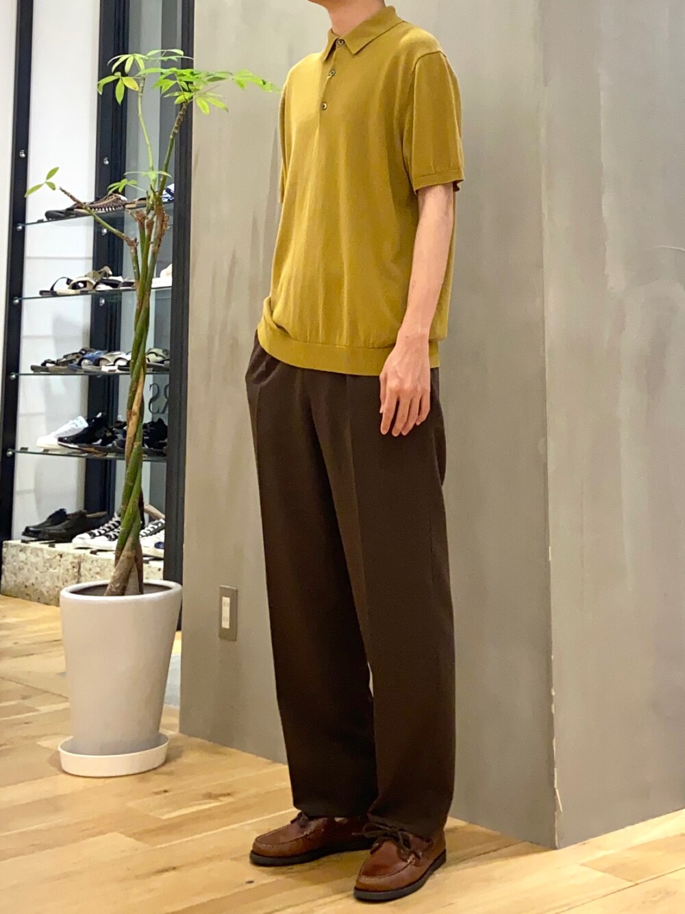 イエロー系のポロシャツ、ブラウン系のその他パンツを着用したメンズの夏コーディネートの3枚目の写真