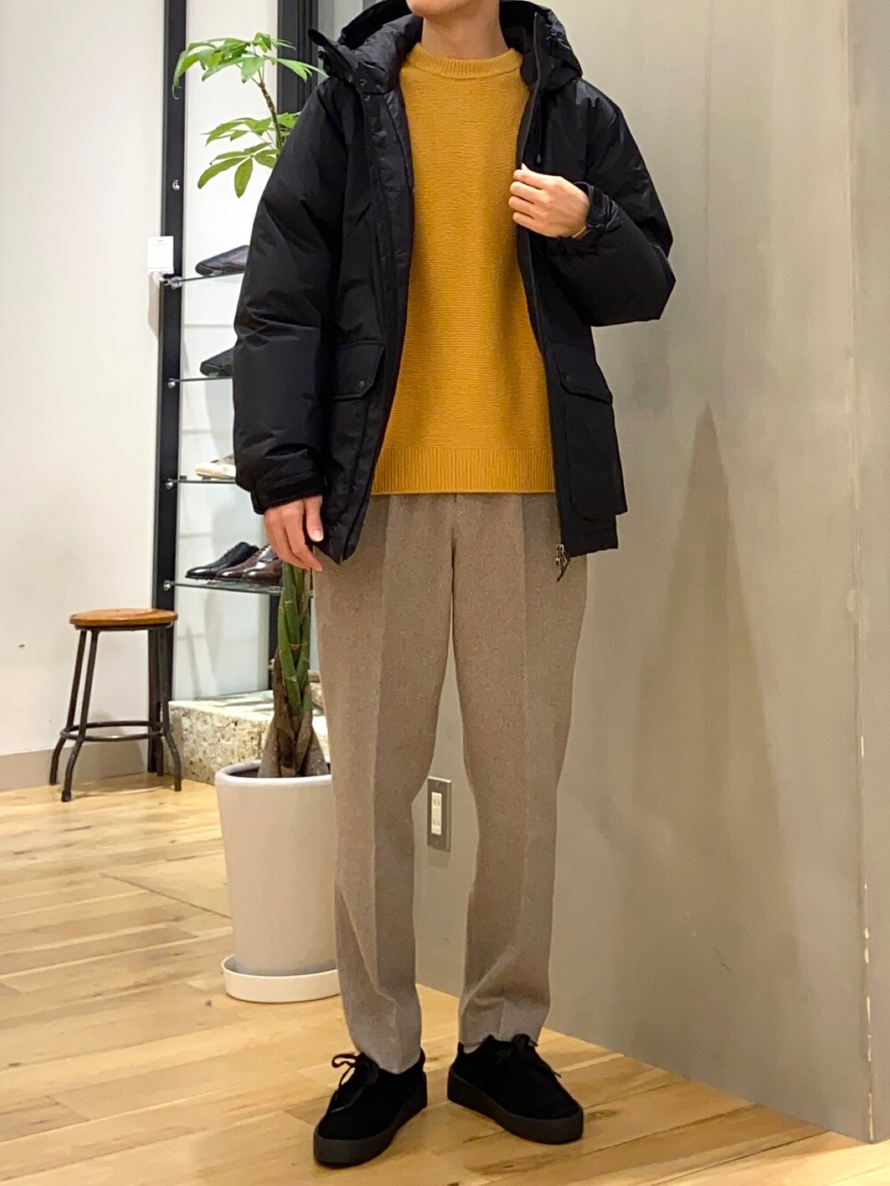 ブラック系のダウンジャケット/コート、イエロー系のニット/セーター、ブラック系のその他シューズを着用したメンズの冬コーディネートの4枚目の写真