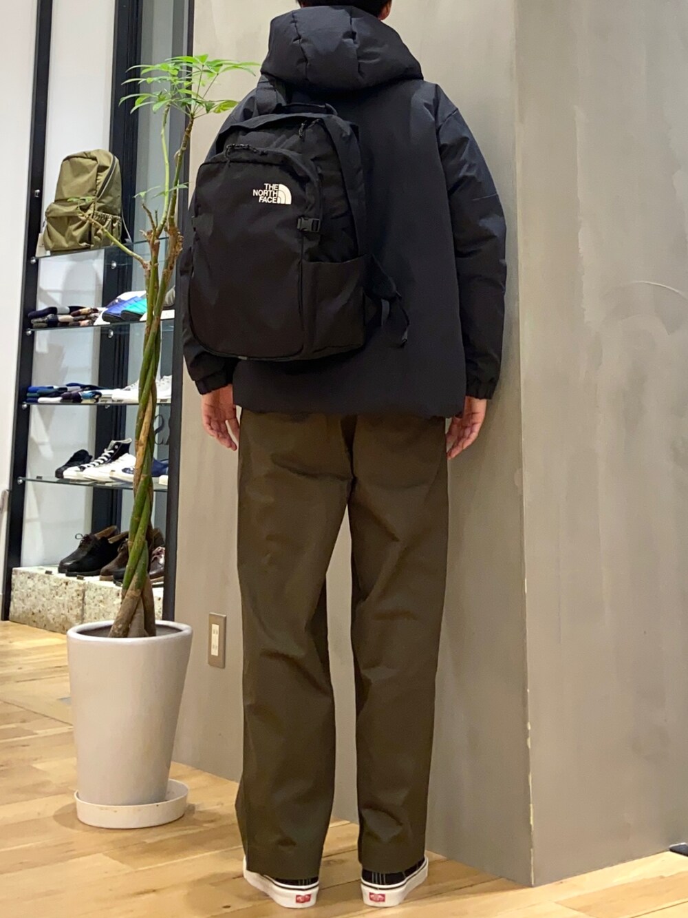 ブラック系のダウンジャケット/コート、ホワイト系のニット/セーター、ブラック系のスニーカーを着用したメンズの冬コーディネートの4枚目の写真