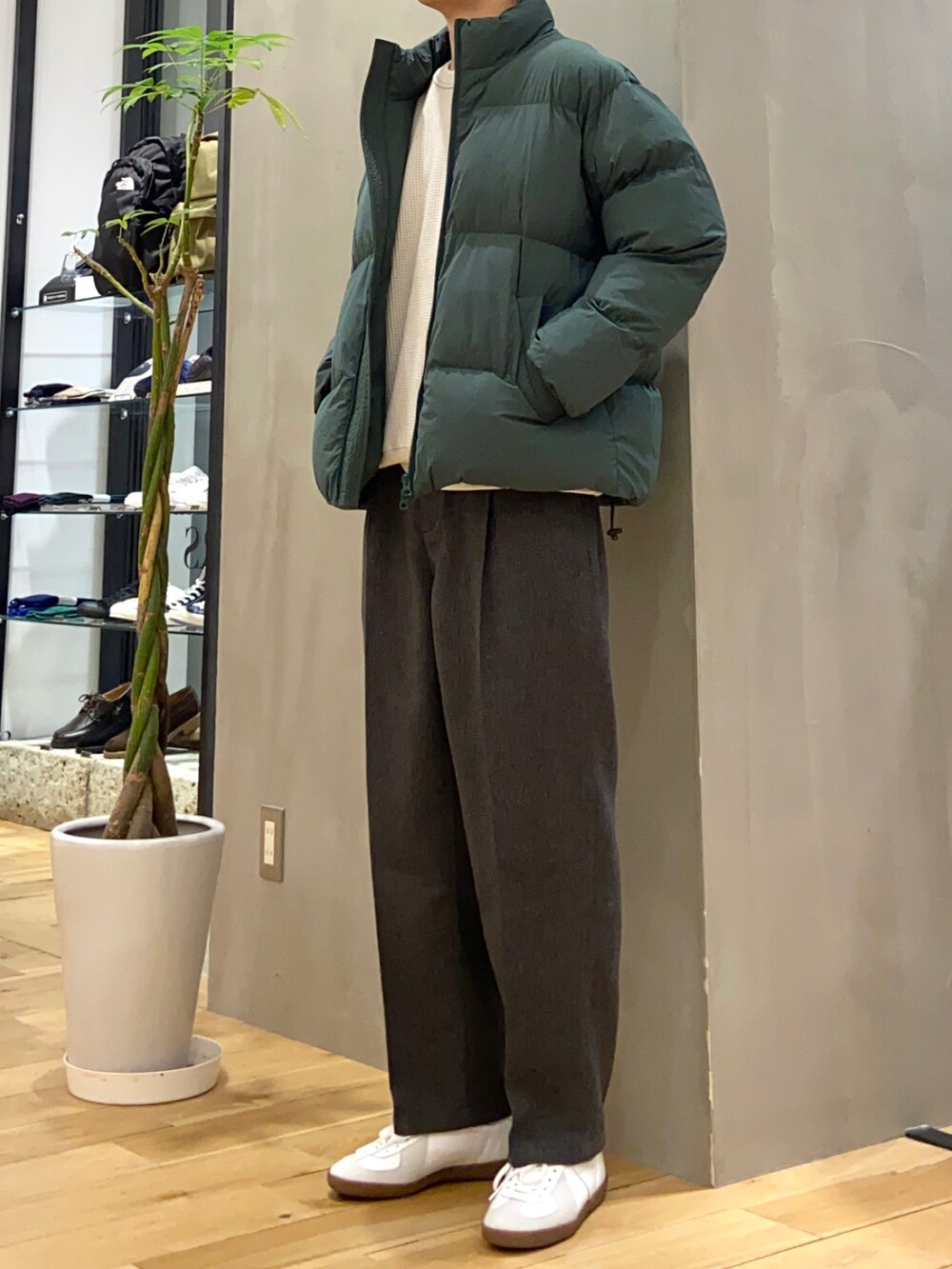 グリーン系のダウンジャケット/コート、ベージュ系のTシャツ/カットソー、ホワイト系のスニーカーを着用したメンズの冬コーディネートの3枚目の写真