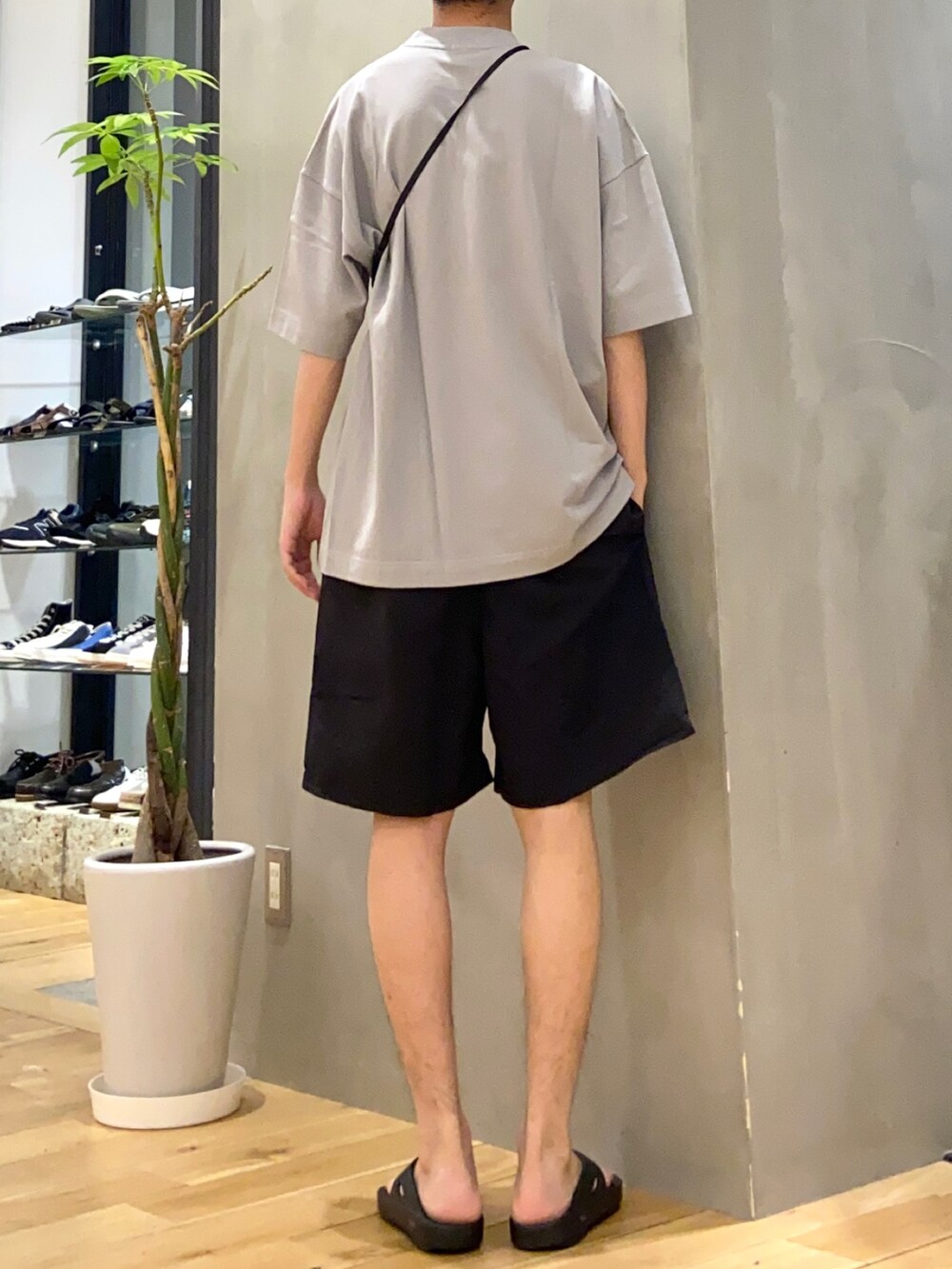 グレー系のTシャツ/カットソー、ブラック系のショルダーバッグ、ブラック系のサンダルを着用したメンズの夏コーディネートの3枚目の写真