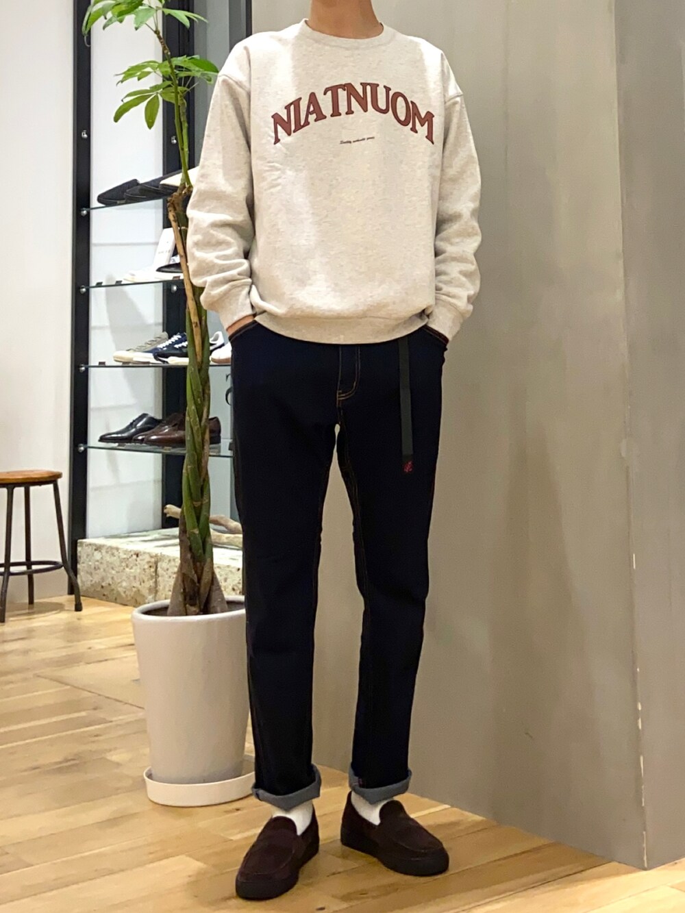 ベージュ系のチェスターコート、ホワイト系のスウェット、ブラウン系のローファーを着用したメンズの冬コーディネートの2枚目の写真