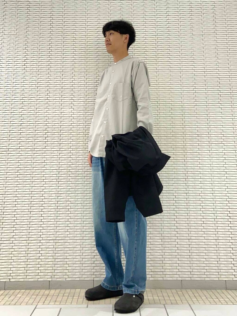 ブルー系のデニムパンツ、グレー系のシャツ/ブラウス、ブラック系のブルゾンを着用したメンズの秋コーディネートの2枚目の写真