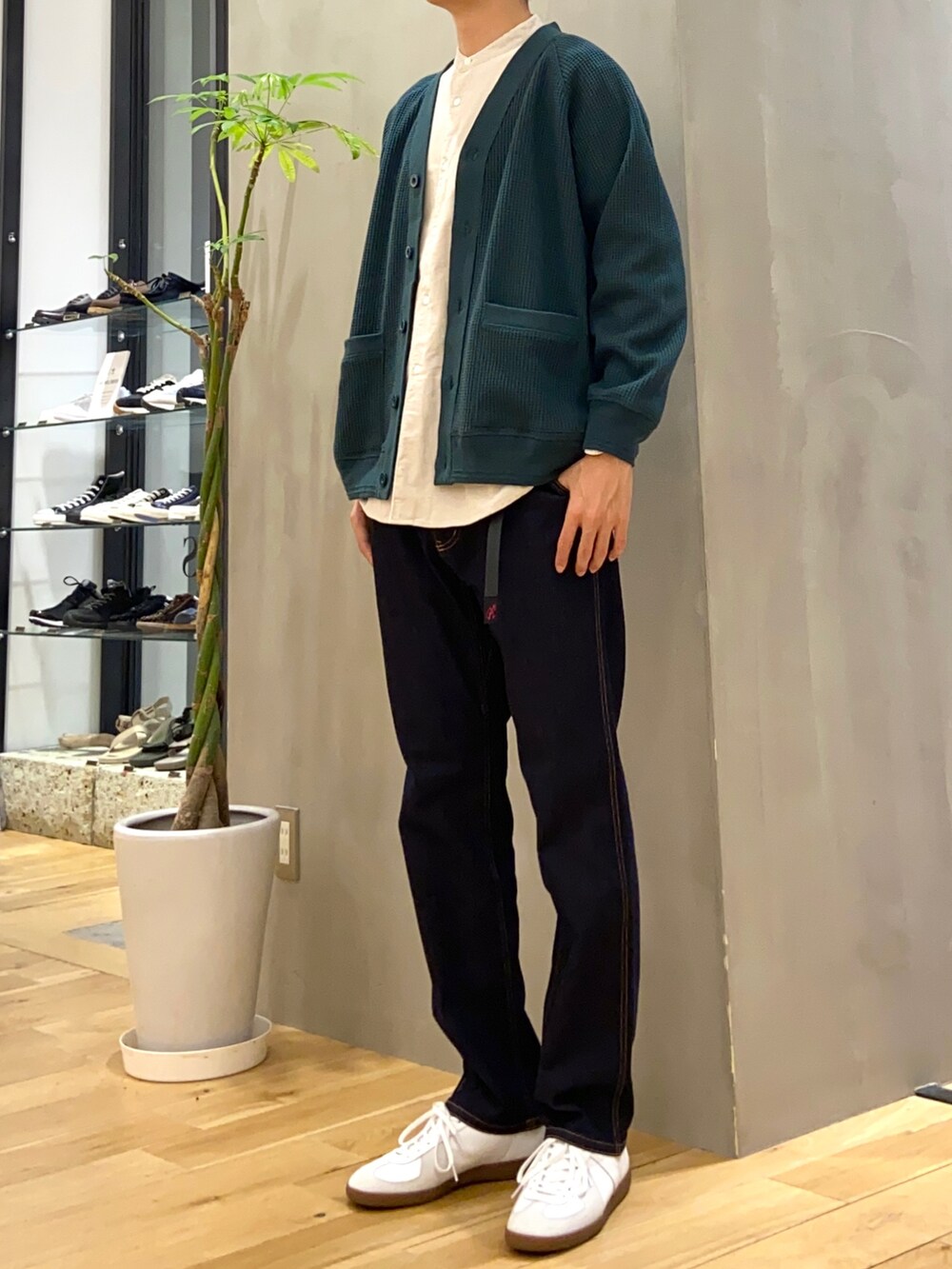 グリーン系のカーディガン/ボレロ、ベージュ系のシャツ/ブラウス、ホワイト系のスニーカーを着用したメンズの秋コーディネートの2枚目の写真