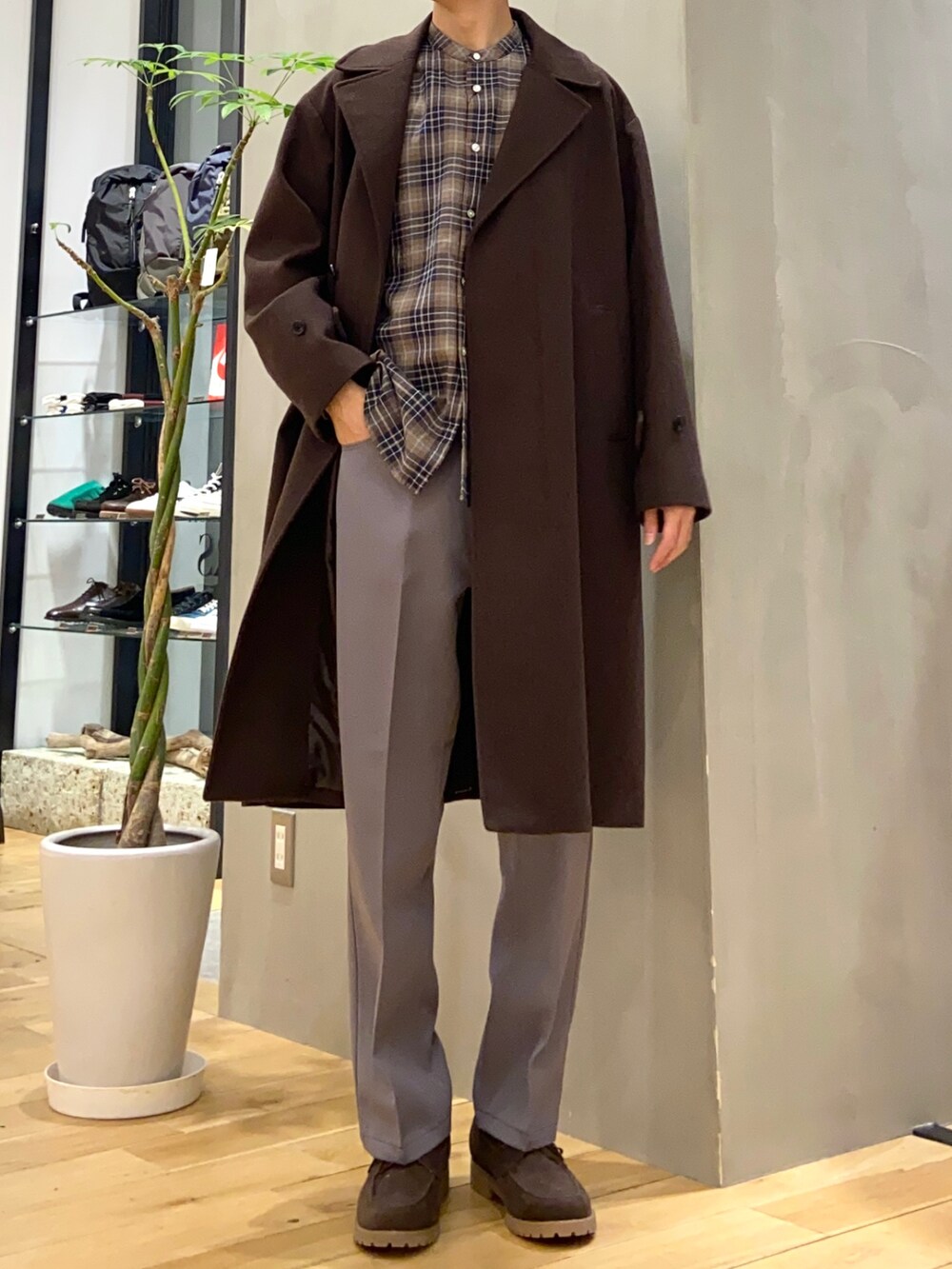 ブラウン系のチェスターコート、ブラウン系のその他シューズ、グレー系のその他パンツを着用したメンズの冬コーディネートの2枚目の写真