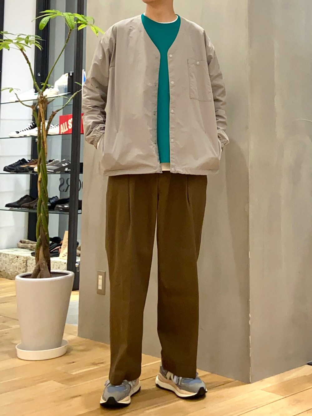 グレー系のナイロンジャケット、グリーン系のTシャツ/カットソー、ホワイト系のTシャツ/カットソーを着用したメンズの春コーディネートの4枚目の写真