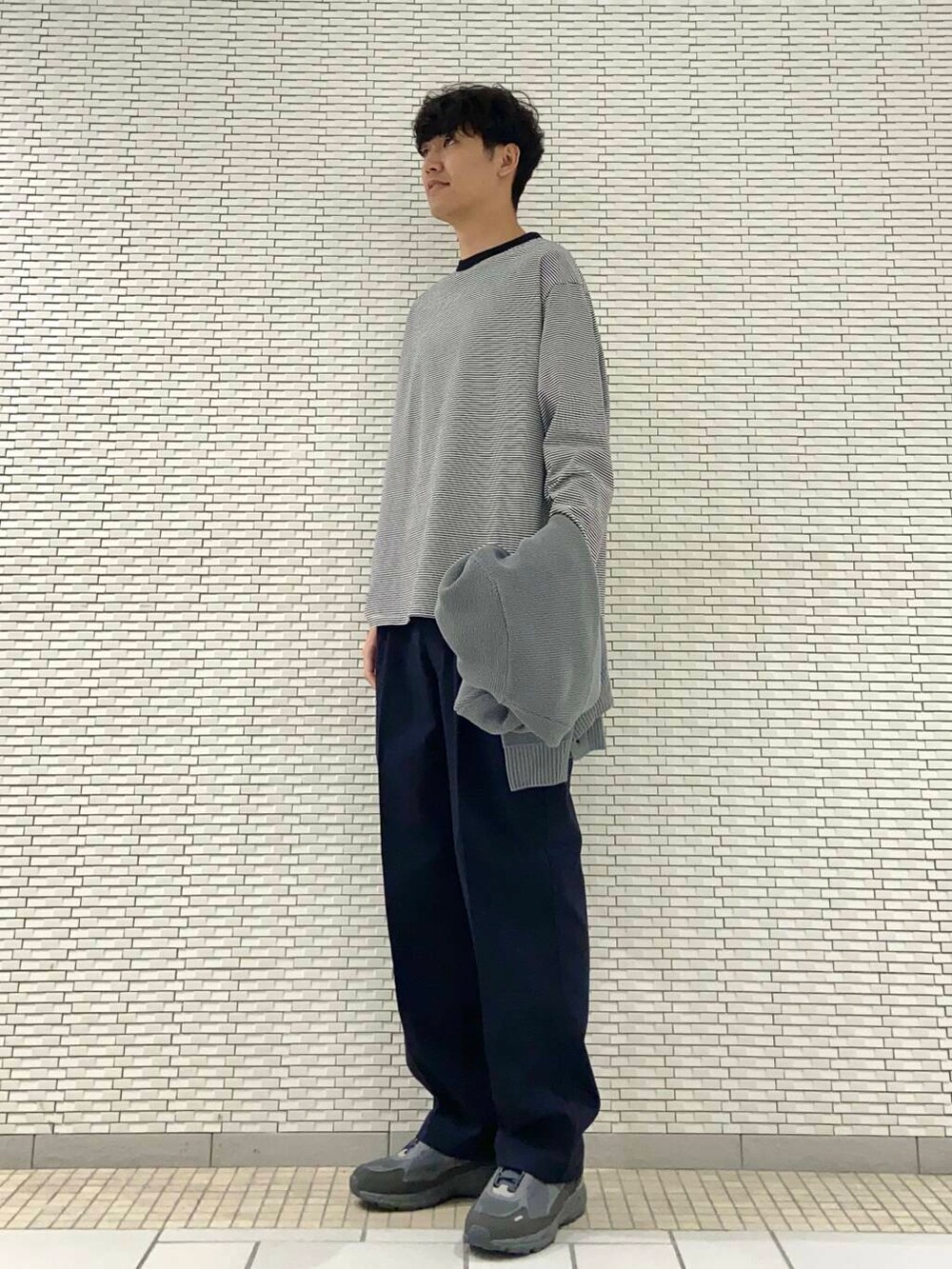 ブラック系のTシャツ/カットソー、グレー系のカーディガン/ボレロ、ブルー系のその他パンツを着用したメンズの秋コーディネートの2枚目の写真