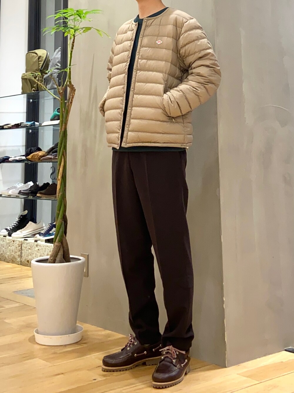 ベージュ系のダウンジャケット/コート、グリーン系のTシャツ/カットソー、ブラウン系のスニーカーを着用したメンズの冬コーディネートの3枚目の写真