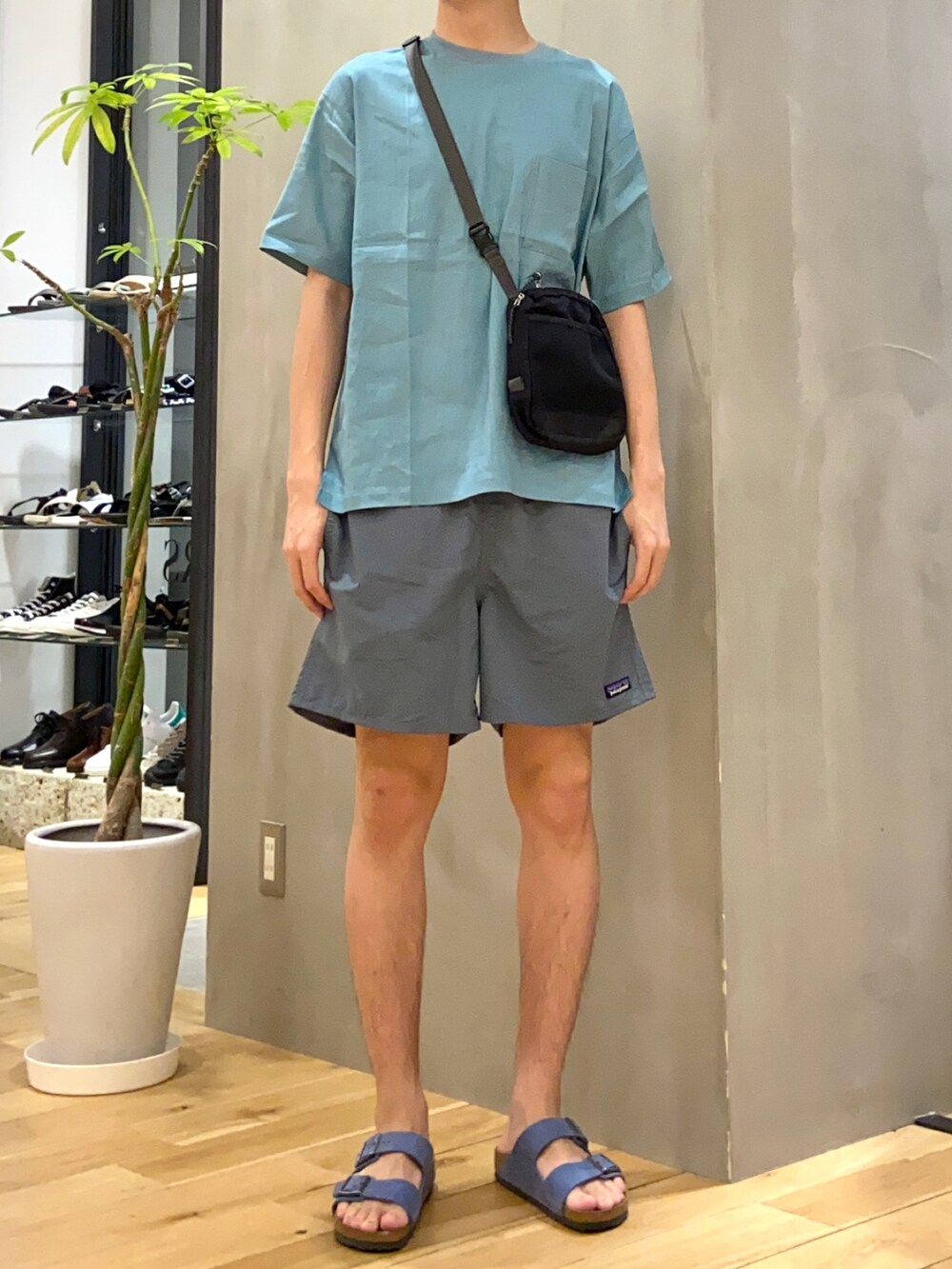 ブルー系のシャツ/ブラウス、ブラック系のショルダーバッグ、ブルー系のサンダルを着用したメンズの夏コーディネートの3枚目の写真