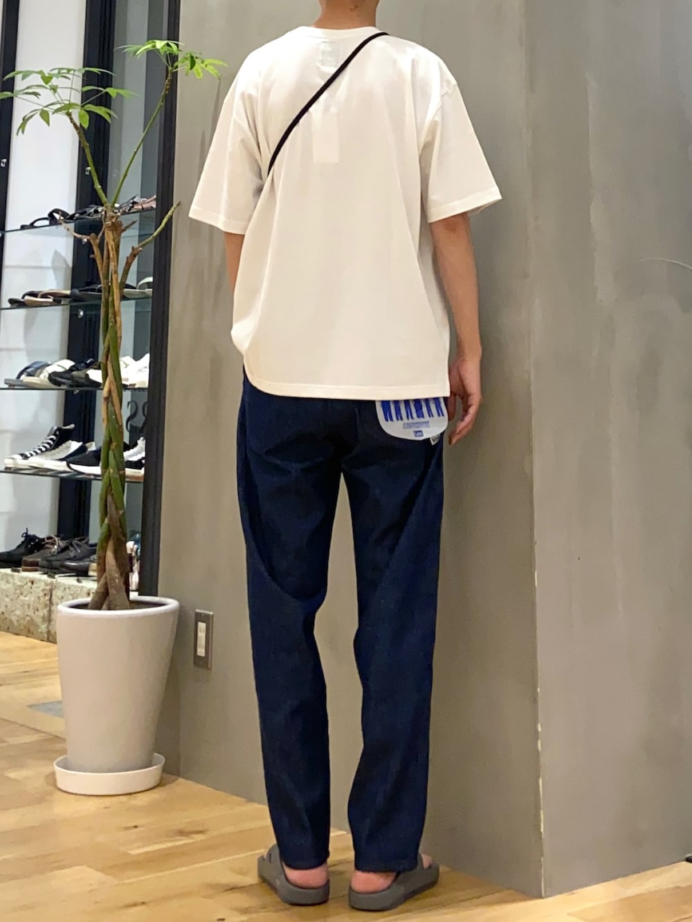 ホワイト系のTシャツ/カットソー、ブルー系のデニムパンツ、グレー系のサンダルを着用したメンズの夏コーディネートの3枚目の写真