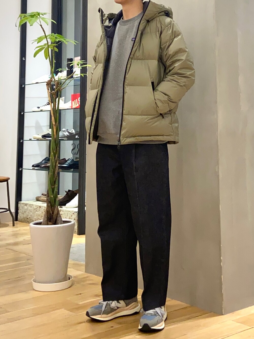 グリーン系のダウンジャケット/コート、ブルー系のデニムパンツ、グレー系のスニーカーを着用したメンズの冬コーディネートの2枚目の写真