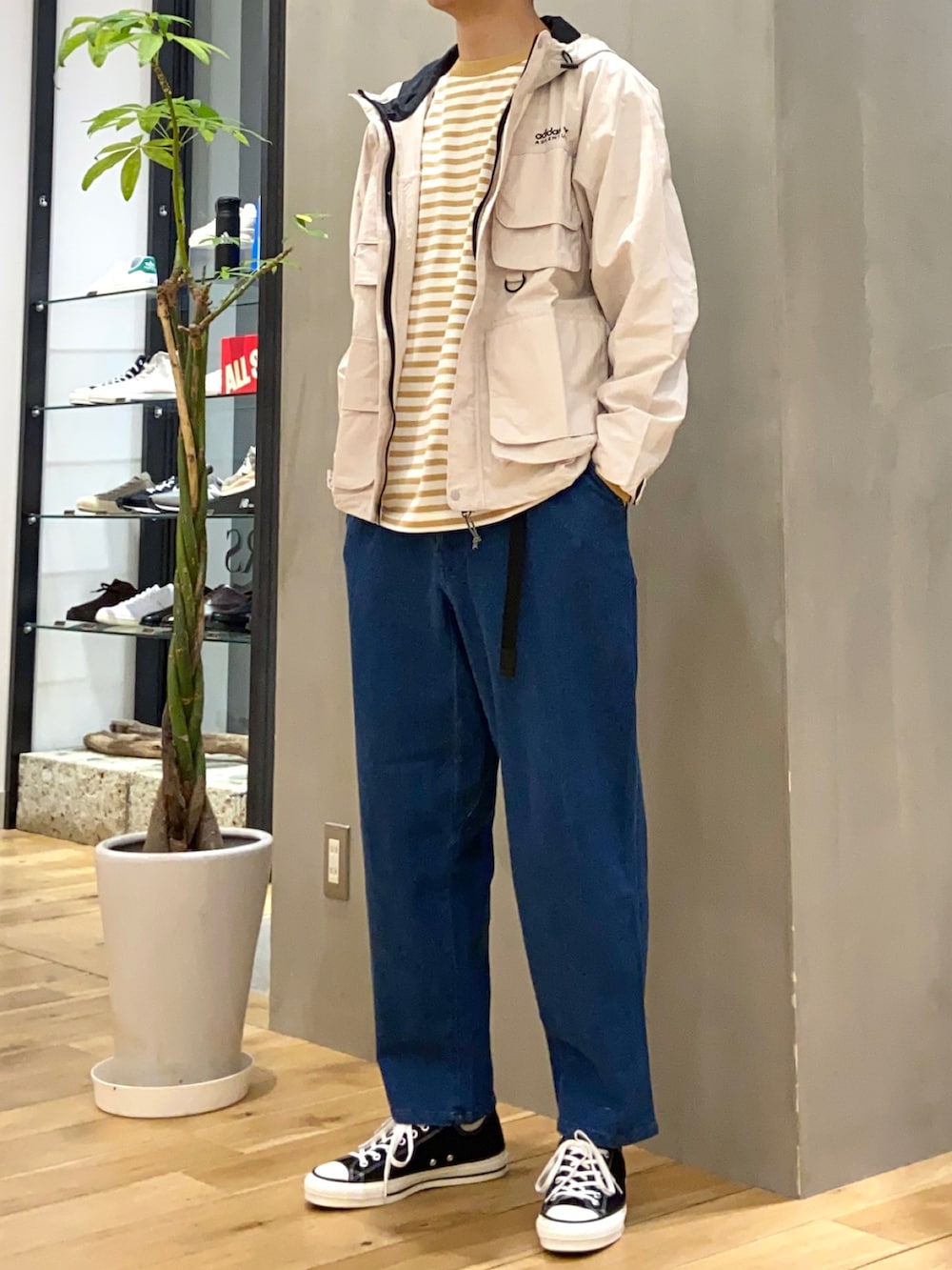 ベージュ系のマウンテンパーカー、イエロー系のTシャツ/カットソー、ブルー系のデニムパンツを着用したメンズの春コーディネートの4枚目の写真