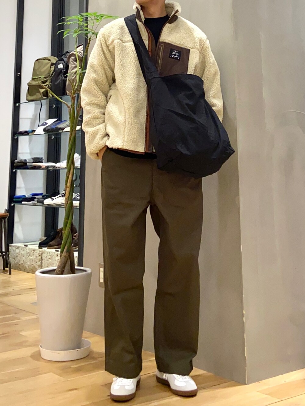 ベージュ系のブルゾン、ブラック系のショルダーバッグ、グリーン系のその他パンツを着用したメンズの冬コーディネートの3枚目の写真