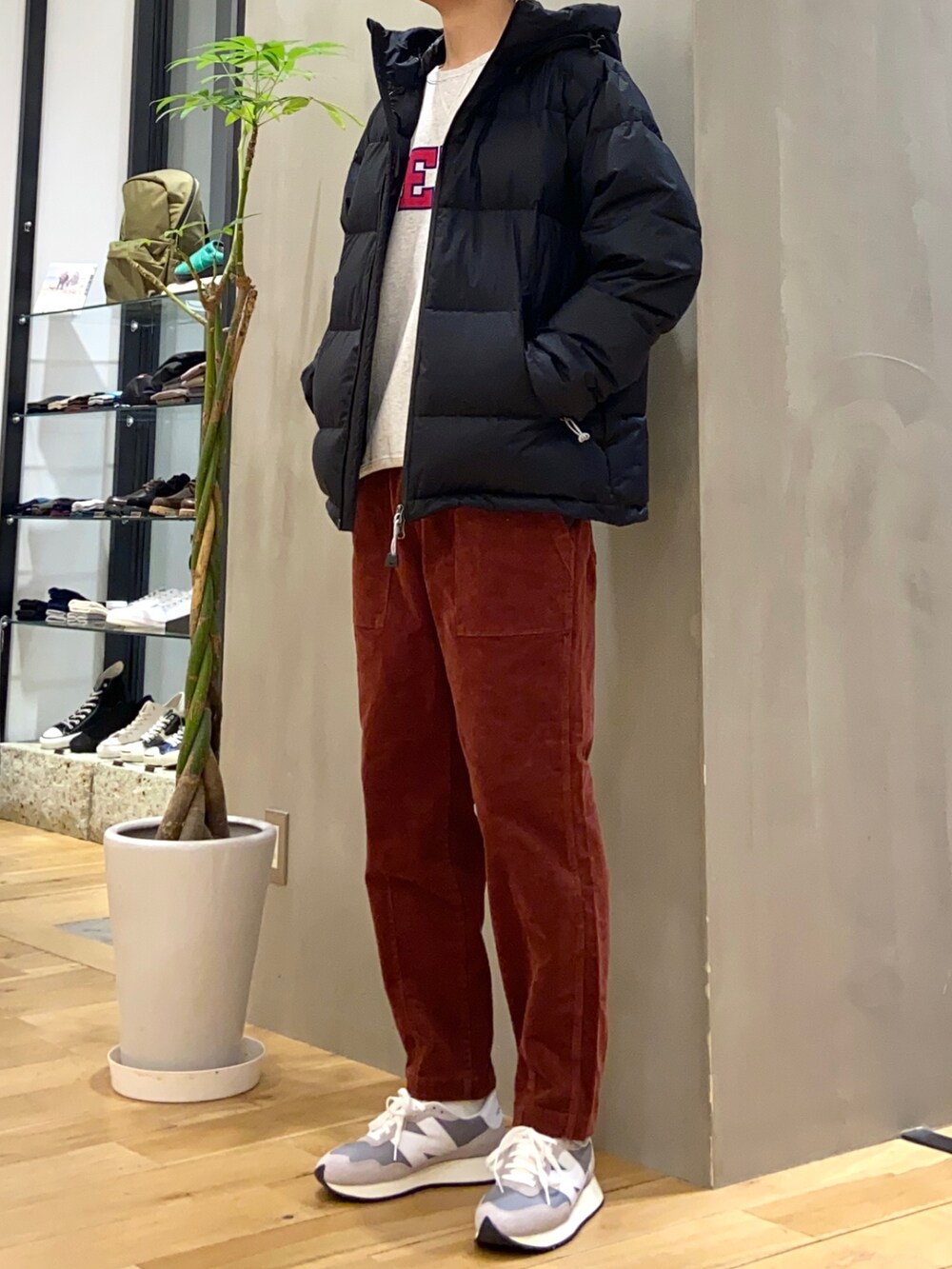 ブラック系のダウンジャケット/コート、グレー系のスウェット、オレンジ系のその他パンツを着用したメンズの秋コーディネートの3枚目の写真