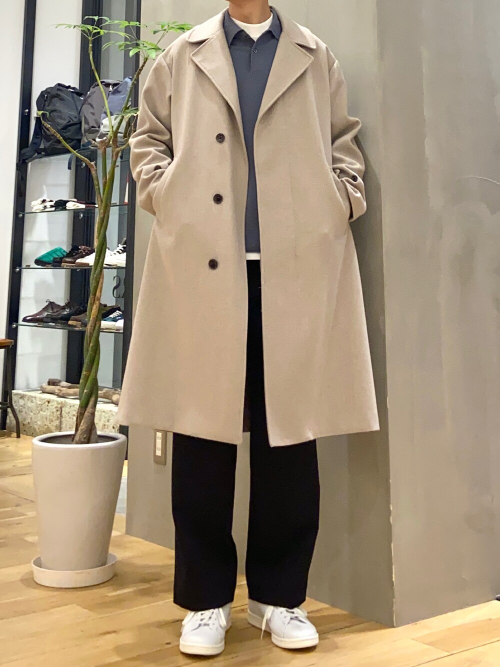 グレー系のチェスターコート、ホワイト系のTシャツ/カットソー、ブルー系のその他パンツを着用したメンズの冬コーディネートの3枚目の写真