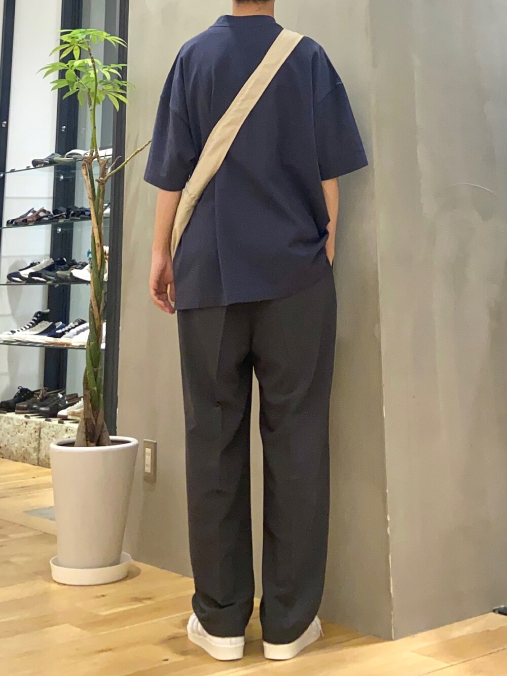 ブルー系のTシャツ/カットソー、グレー系のショルダーバッグ、グレー系のスラックスを着用したメンズの春コーディネートの3枚目の写真