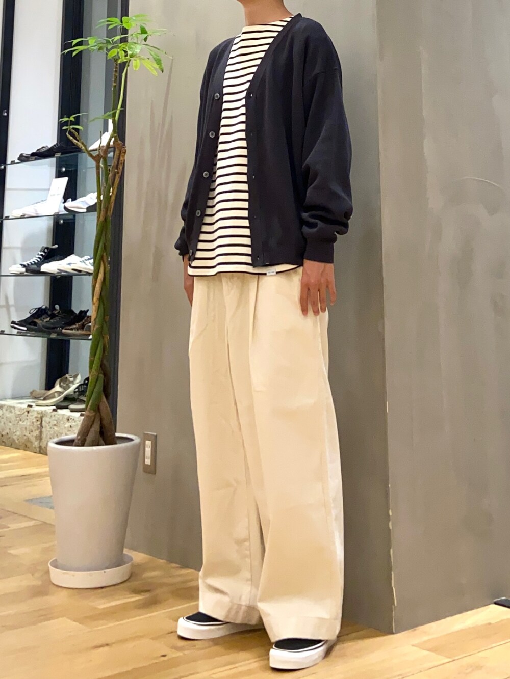 グレー系のカーディガン/ボレロ、ホワイト系のTシャツ/カットソー、ブラック系のスニーカーを着用したメンズの秋コーディネートの2枚目の写真