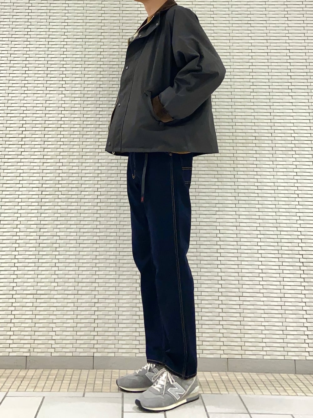 グリーン系のダウンジャケット/コート、オレンジ系のTシャツ/カットソー、ブルー系のその他パンツを着用したメンズの秋コーディネートの3枚目の写真