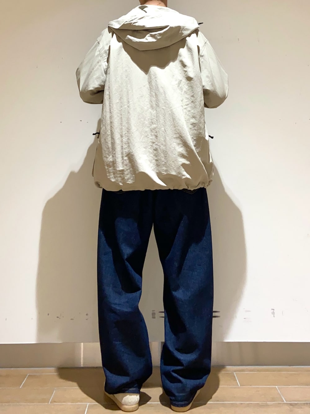 ベージュ系のマウンテンパーカー、ホワイト系のTシャツ/カットソー、ブルー系のデニムパンツを着用したメンズの春コーディネートの5枚目の写真