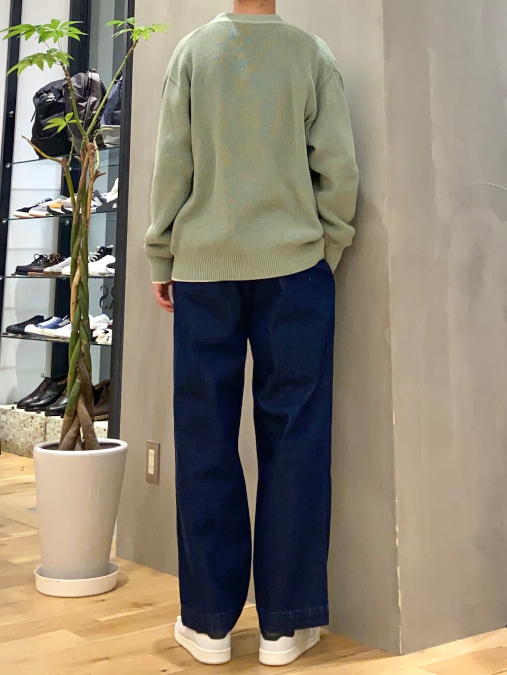 グリーン系のカーディガン/ボレロ、ホワイト系のTシャツ/カットソー、ブルー系のデニムパンツを着用したメンズの冬コーディネートの3枚目の写真
