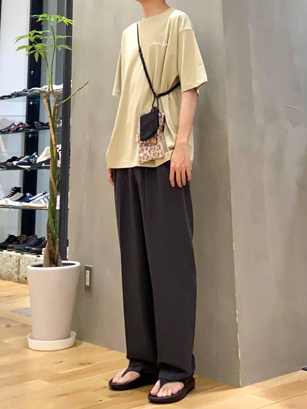 ベージュ系のTシャツ/カットソー、その他のショルダーバッグ、グレー系のスラックスを着用したメンズの春コーディネートの2枚目の写真